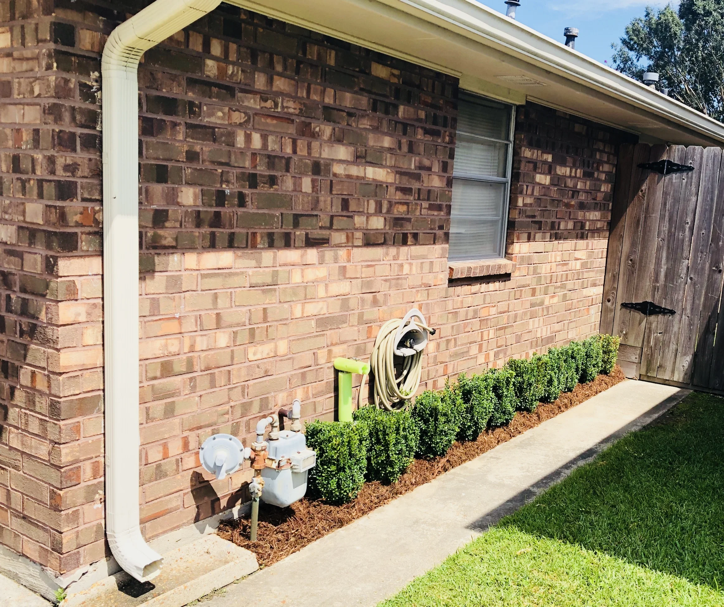 Fresh boxwoods dress up the side of this Kenner home.