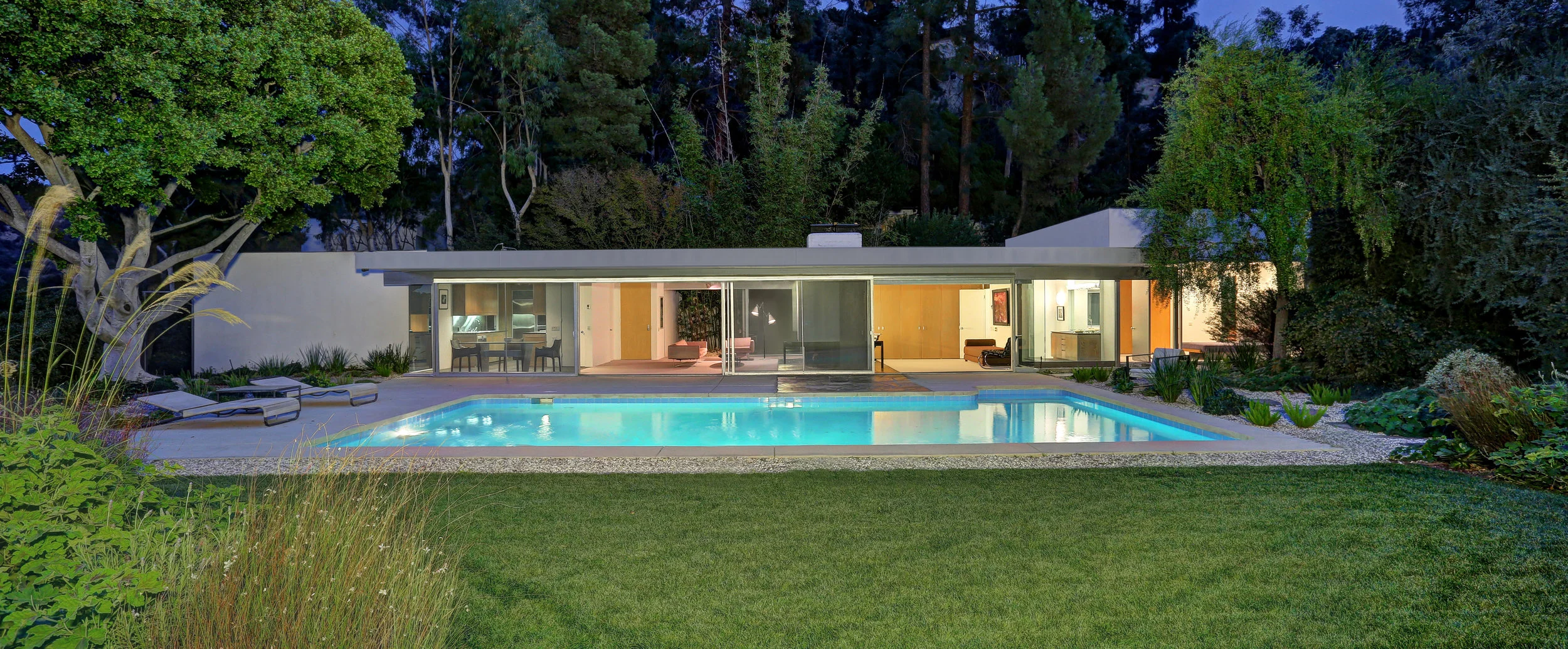 2456 Astral Drive | Hollywood Hills SOLD! $5,625,000 Artful Master Suite Addition by Escher GuneWardena & Guest House | Art Studio by Steven Ehrlich, FAIA. With the greatest simplicity, the Loring house offers the ultimate 1950's LA lifestyle. One of Richard Neutra's finest examples of Mid Century boxcar design with oversized retractable glass doors, broad roof overhang and sleek spider leg column facade. Located up a long private gated drive and perched atop knoll overlooking the sylvan canyons of the Hollywood Hills, this home is the epitome of the much sought after indoor outdoor experience which Neutra helped create. A master suite and bath addition, the Baskerville Addition by Escher GuneWardena artfully occupies the location that Neutra had proposed for a future bedroom in the archival plans of the original home. There are an additional two bedrooms and one and one-half baths. The large bright living room opens onto a private bamboo garden as well as the pool, a grassy yard and views. A bold fireplace with a classic Neutra design outrigger support beam provides a sculptural focal point to the room. Magnificent outdoors with gorgeous pool, grassy yard and professionally landscaped gardens. In addition, the property features a two bedroom guest house, Kalfus Guest House with a two-story art studio designed by Steven Ehrlich, FAIA. A rare opportunity to own an architectural treasure.