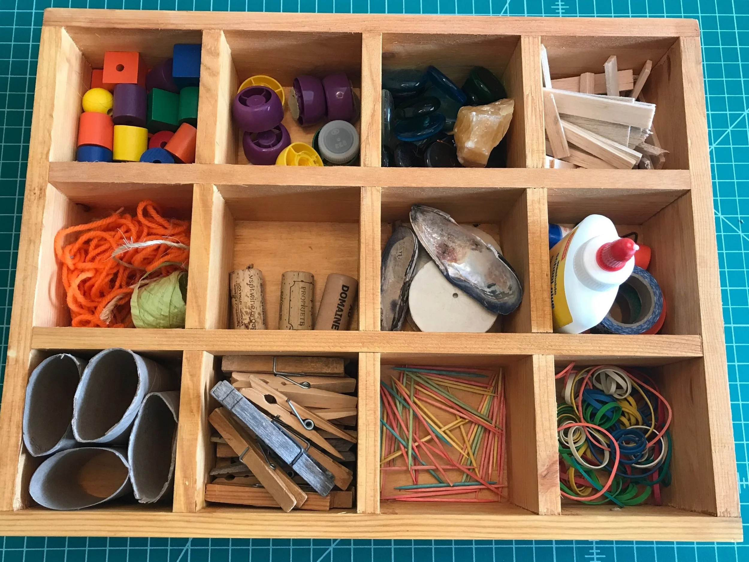 TINKER TRAY Materials: assorted loose parts such as corks, shells, string, toilet rolls, toothpicks, and shells; fasteners like glue, tape or string. Store them in a sectional tray or shadow box with compartments (pictured). Process: Let children explore the materials. Discuss ideas for what you may want to create. For children 4 and up, try drawing a picture of your ideas first, or after they are done. Always supervise when children are using glue gun and/or scissors. Use with other materials such as cardboard, wood pieces, play-dough and more! Words: build, fasten, texture, strong, balance, color words, shape words Questions: What do you think will happen if? What did you make? What does it do? What is it called?
