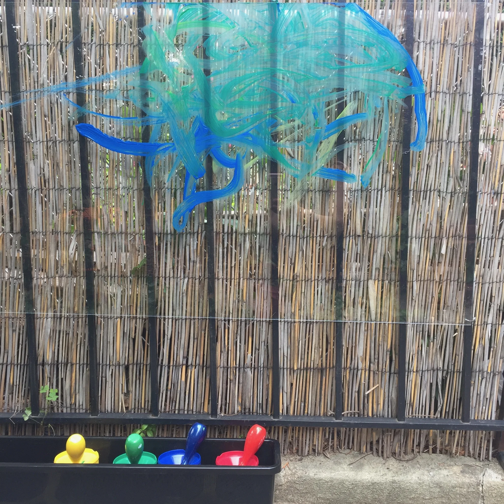 OUTDOOR EASEL Materials: Piece of clear Plexiglas affixed to a fence or other outdoor surface (we drilled holes and used wire), window box planter (for paint storage), cups for paint, brushes, sponges, hose or water source. Process: Painting outdoors is a wonderful sensory experience! Encourage children to get messy, and paint what they see and hear. Make clean-up part of the fun by encouraging them to sponge off their creations. Words: abstract, realist, landscape, still life, color words, movement Questions: What do you think will happen if? What did you make? How can you? How did you?
