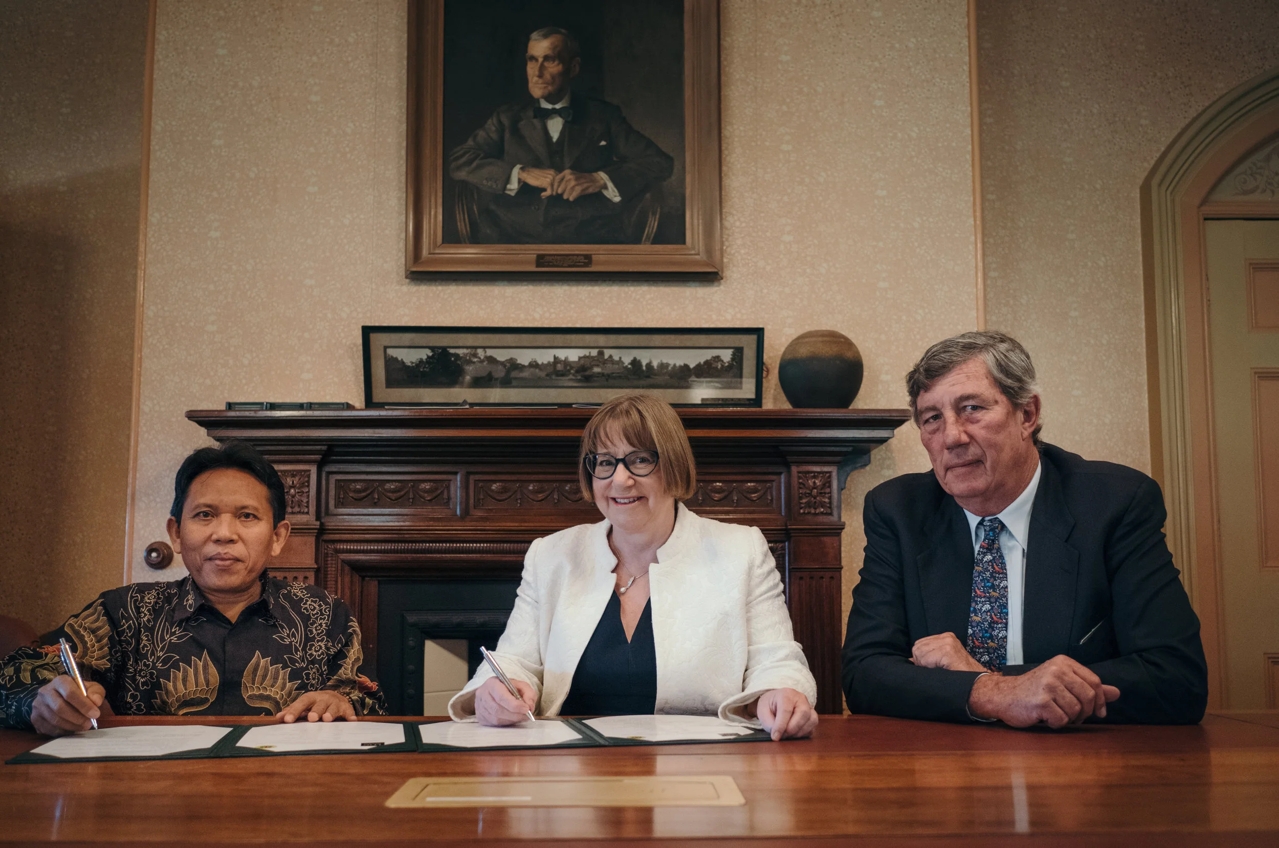 Rector of the University of Mataram, Professor Lalu Husni, signs the MoU with UNE Vice-chancellor, Professor Annabelle Duncan, and Chancellor James Harris. Photo: Matthew Cawood