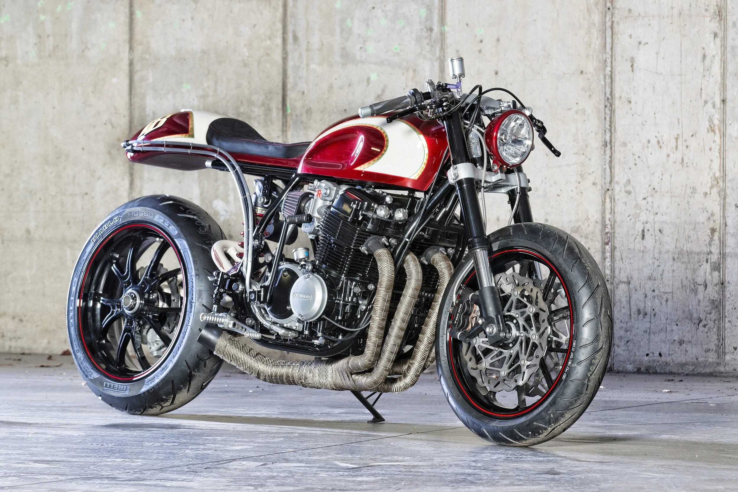 Custom Honda motorcycle named Barely Legal, featuring a café-style design, exposed engine, and handcrafted exhaust and metalwork.