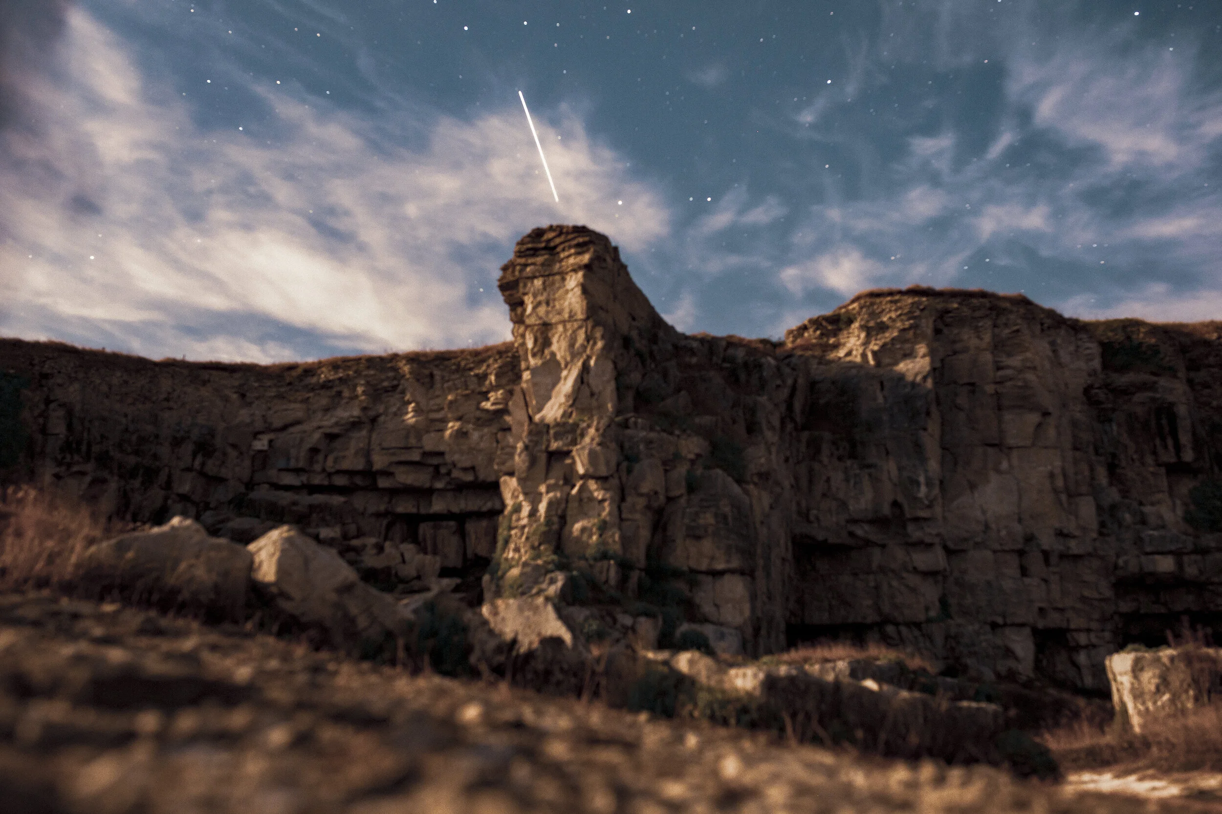 Full moon casting it’s light over the cliffs. A satellite swoops overhead.