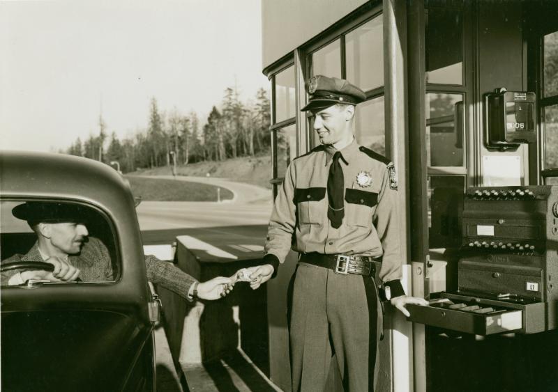 A cheerful toll collector greets a driver heading across Mercer Island to Seattle in 1940.