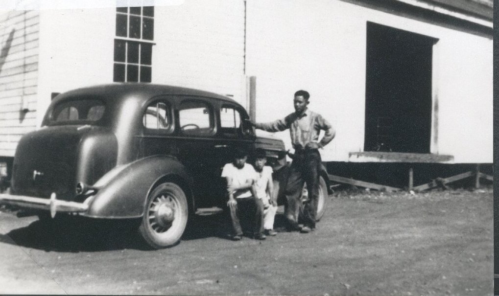 Tom Matsuoka and his sons, Ty and Tats, outside of the Bellevue Vegetable Growers Association shed, a farmer run organization which Tom helped create in the 1930s.