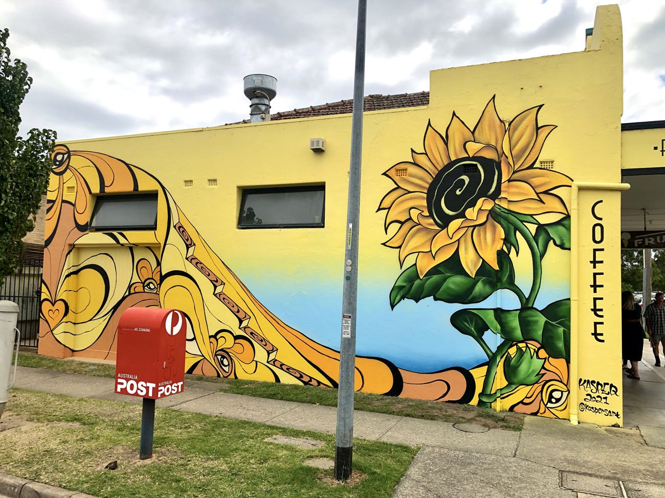Sunflower mural painted on Deli Bean Cafe by Lukas Kasper