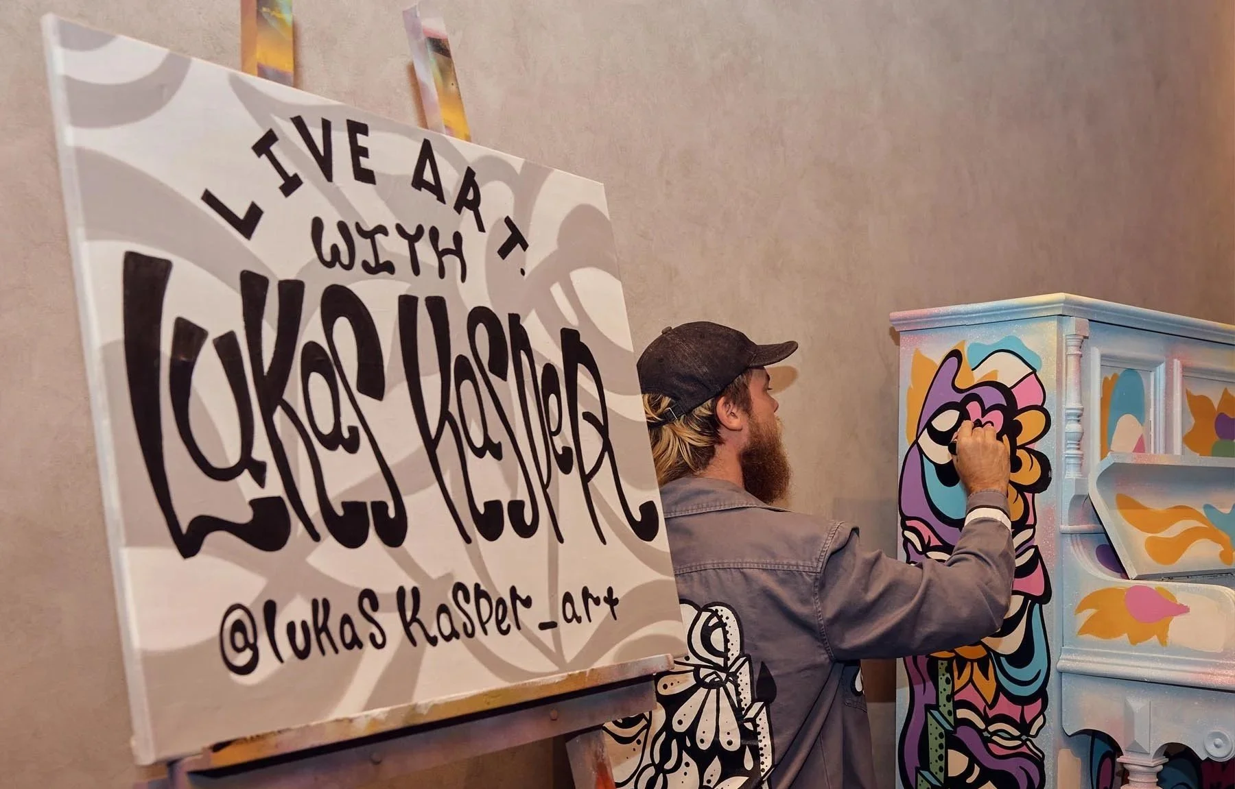 Melbourne live event painter Lukas Kasper creating a vibrant piano artwork at LYF Hotel opening in Melbourne CBD.