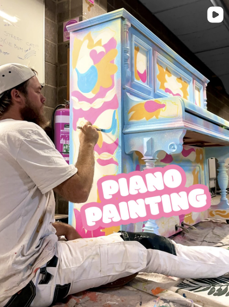 Melbourne live event painter Lukas Kasper creating a vibrant piano artwork at LYF Hotel opening in Melbourne CBD.