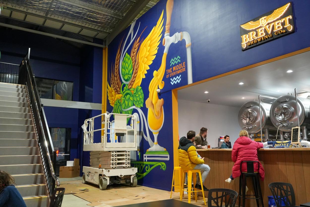 Brevet Brewing floor-to-ceiling brewery mural in Sale, Victoria, created by Melbourne mural artist Lukas Kasper in collaboration with The Middle of Everywhere, featuring aviation-inspired wings and abstract design.