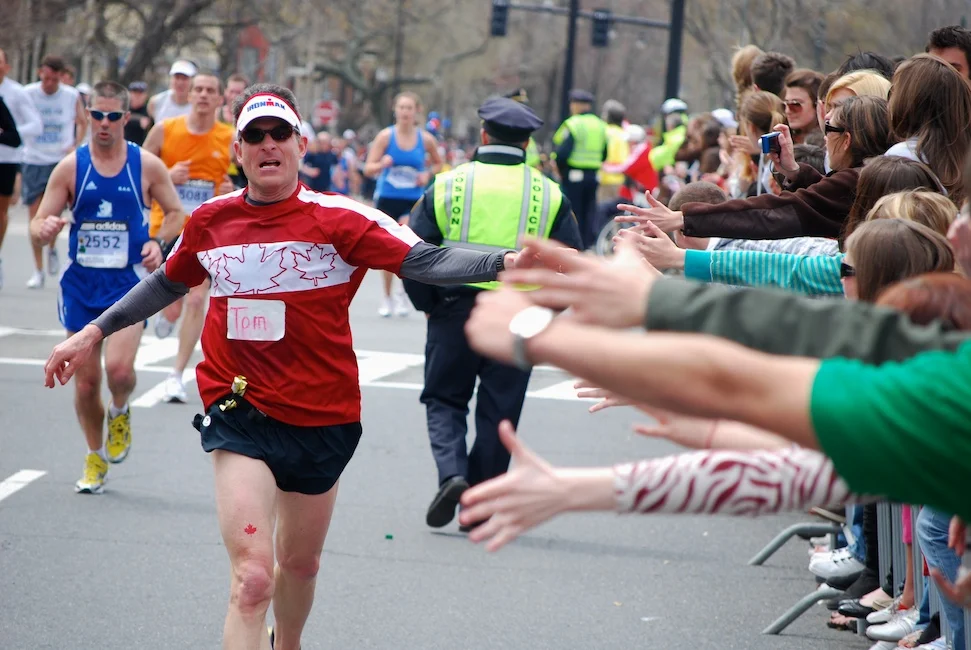 Boston, Mass. - April 20, 2009: A runner gets encouragement and high-fives from spectators at Audubon Circle, the last stretch of the Boston Marathon.
