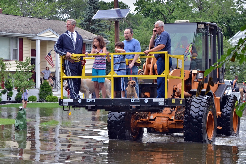  Westwood, NJ - June 23, 2011: Borough administrator Robert Hoffmann (left) and Westwood Firefighter Kevin Woods (right) assist Robert Ouellette in evacuating his family (center) after a broken dam caused the third major flood of the year.  