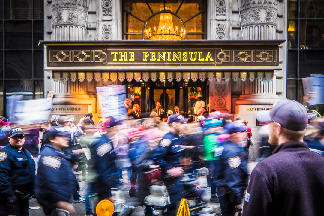  New York, NY - Jan. 21, 2017: Protesters pass by The Peninsula Hotel on 5th Ave. as part of The Women’s March on NYC. The protest took place the day after the Presidential inauguration of Donald Trump and concluded at Trump Tower. 