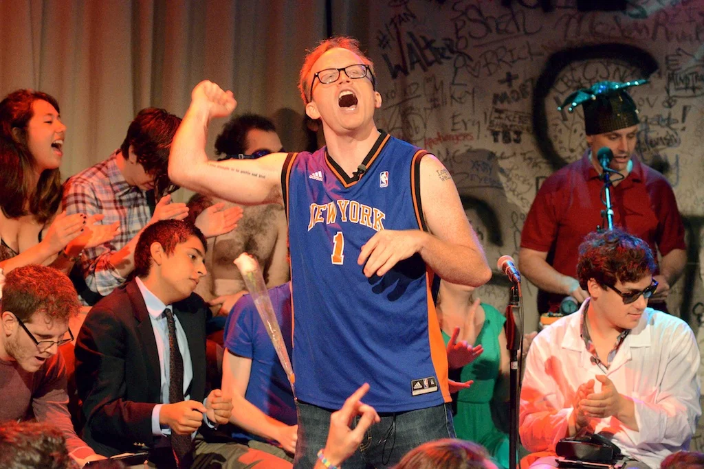 Chris Gethard joins the audience in an chant during the show's 100th episode.