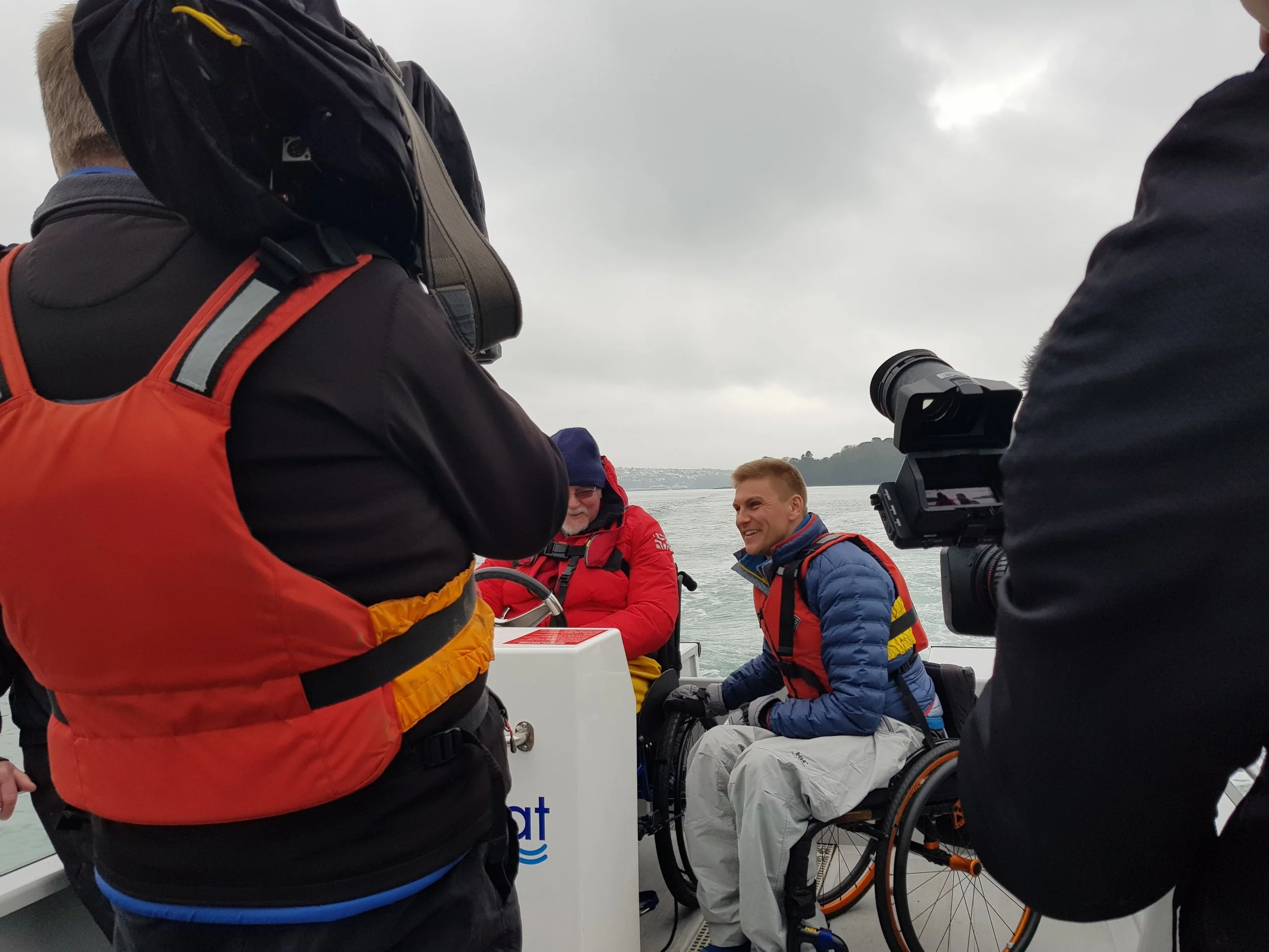 Countryfile presenter, Steve Brown, interviews North Wales Sailability volunteer, Ian Roberts, at the V20’s helm.
