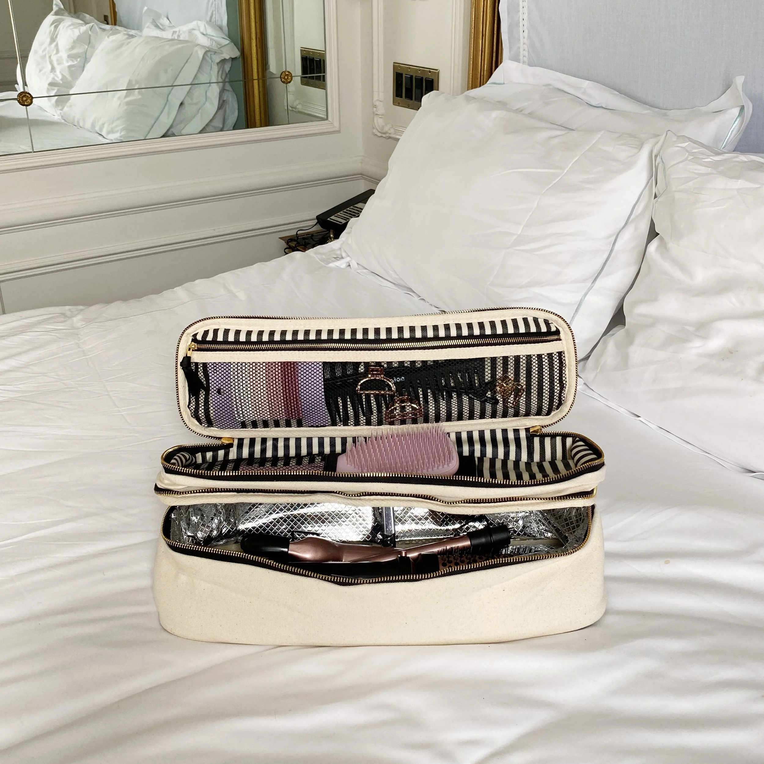 Hair tools organized inside travel case with compartments for styling tools and brushes