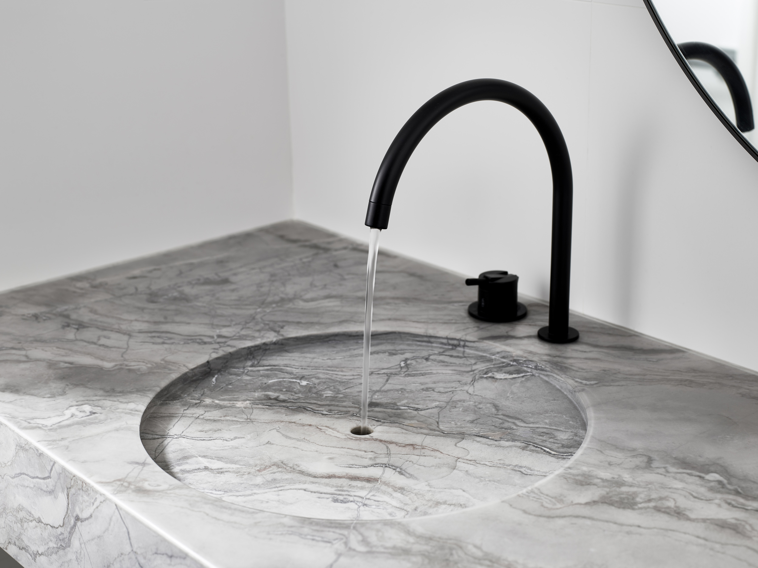 Modern bathroom design with a custom stone sink by Walker Architects.