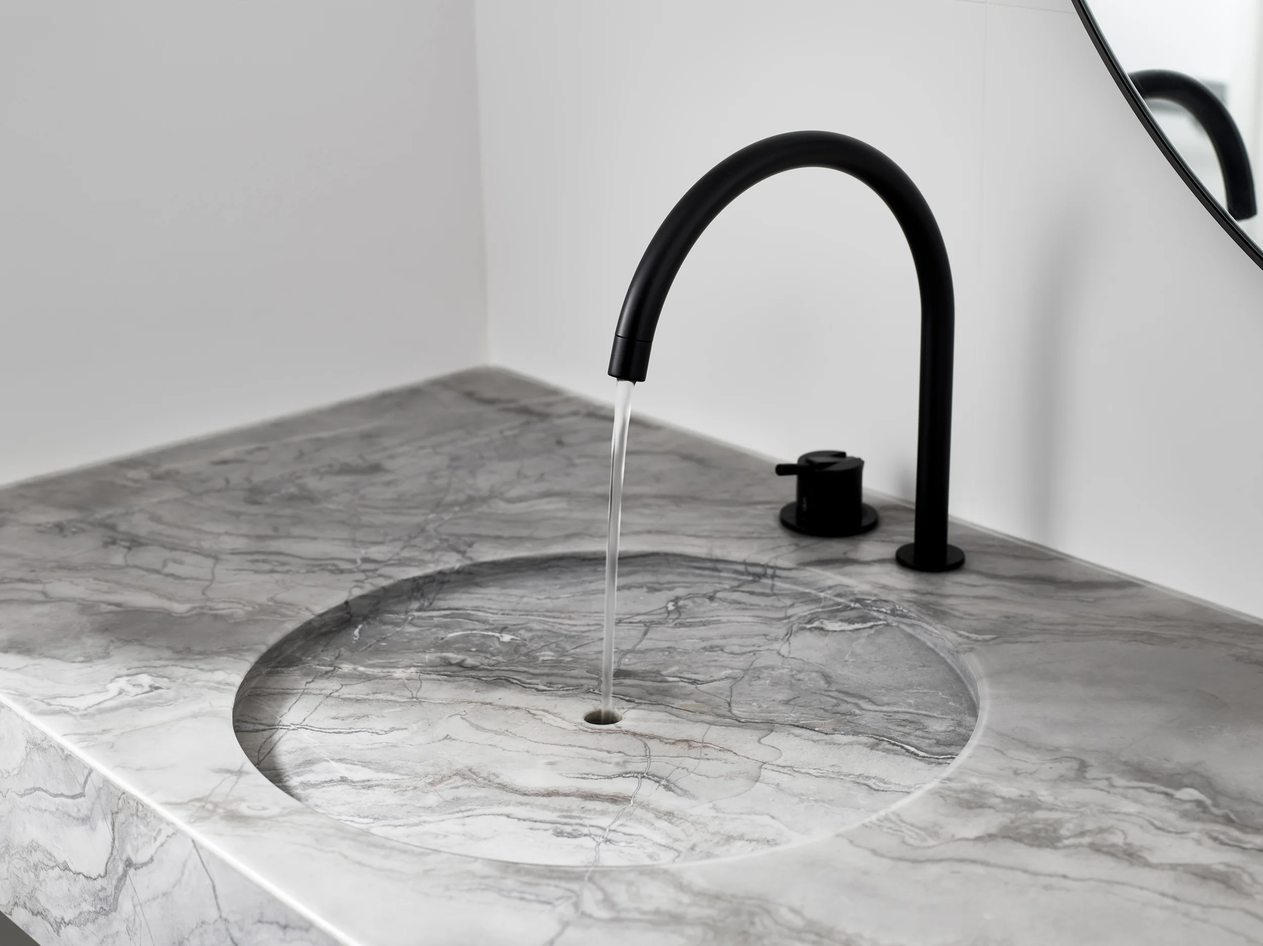 Modern bathroom design with a custom stone sink by Walker Architects.