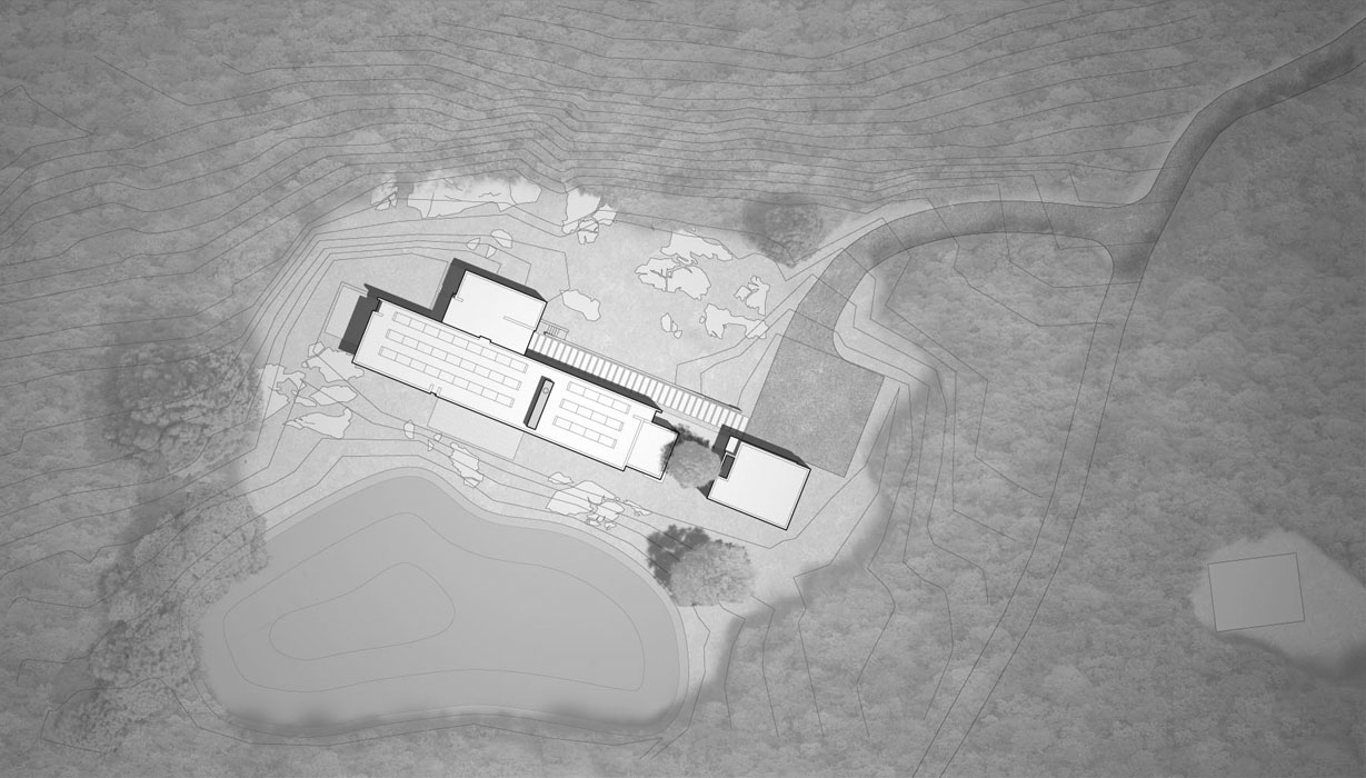 Top-down architectural site plan of a large building complex surrounded by trees, topographical contour lines, and a pond.