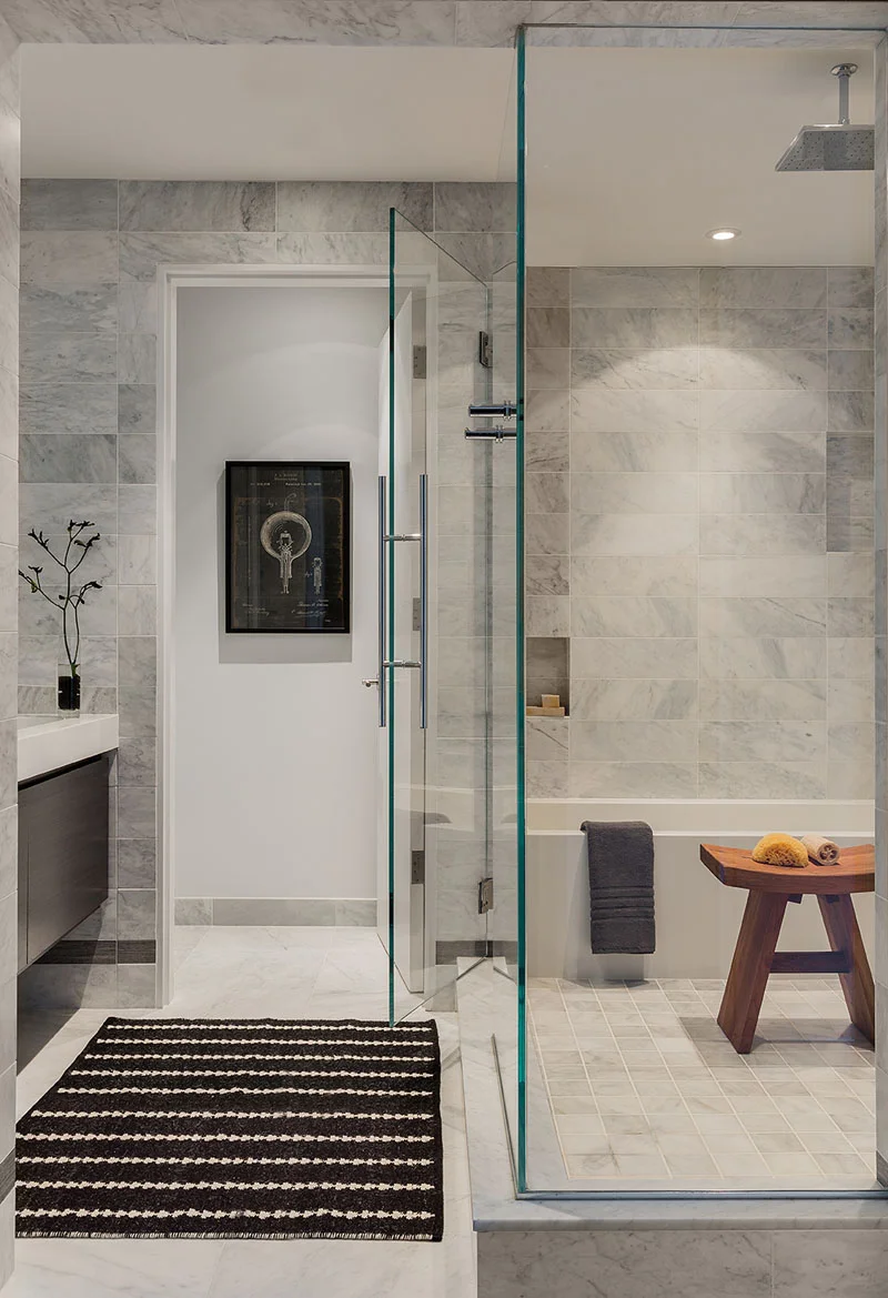 A wet-room style bathroom with glass enclosed bathtub and shower in a renovated Boston Townhouse