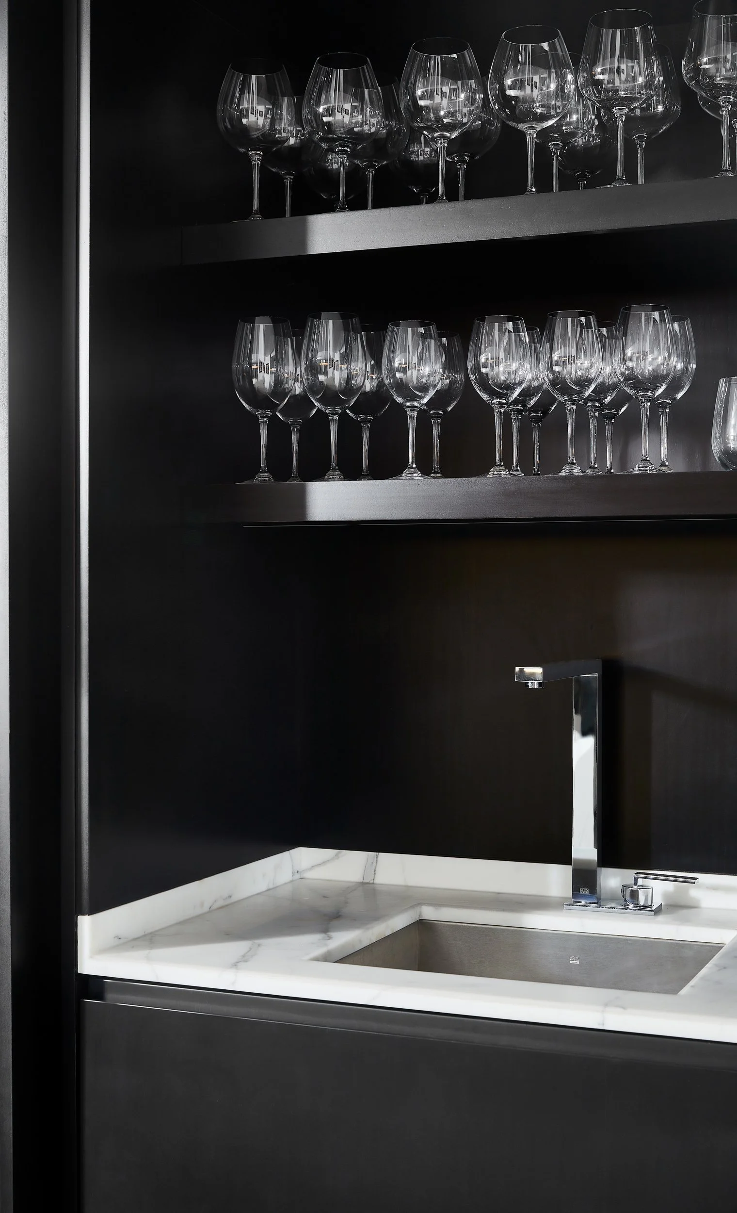 Modern wet bar design details featuring marble and dark wood cabinets