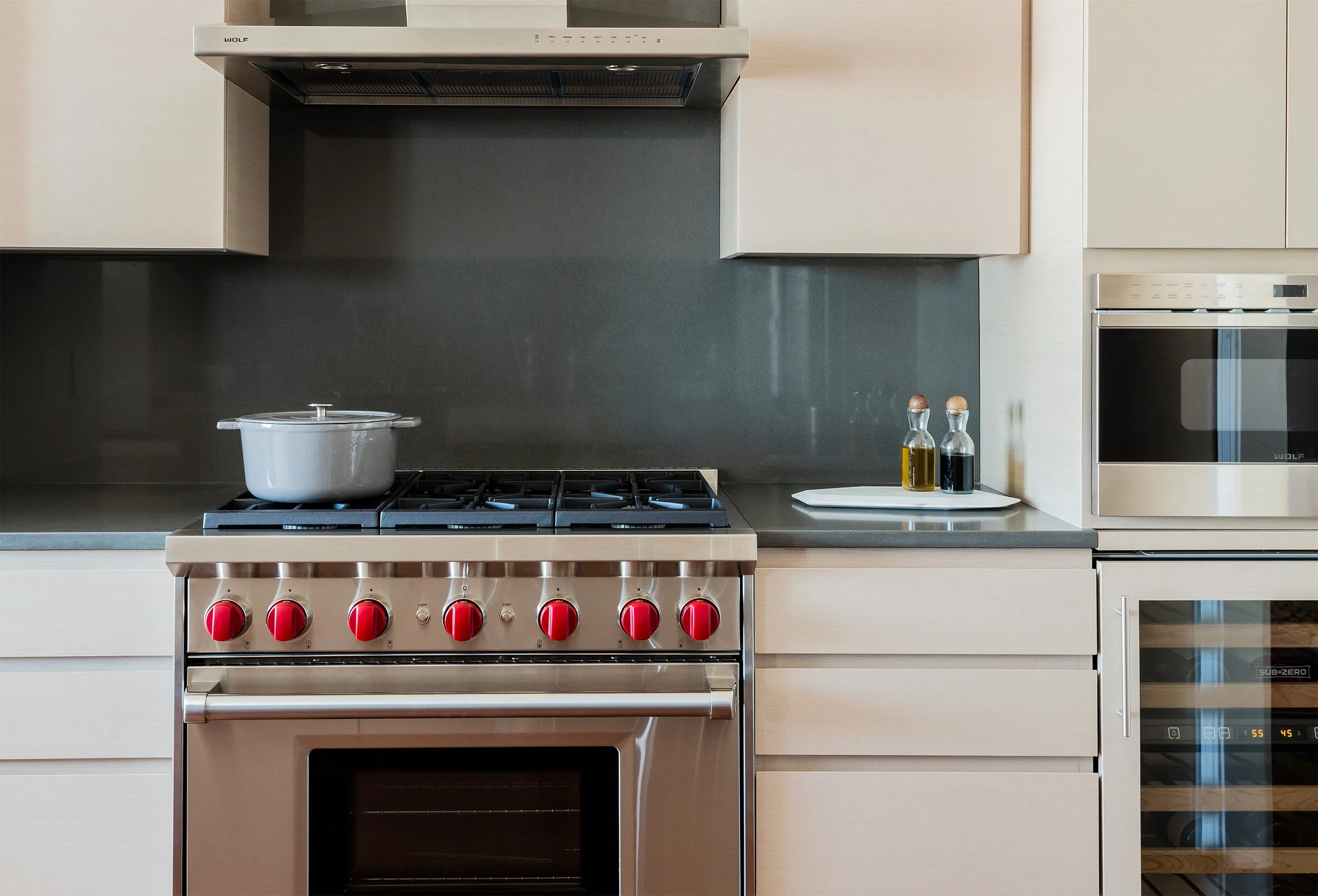 A modern kitchen with high-performance appliances and a slab backsplash
