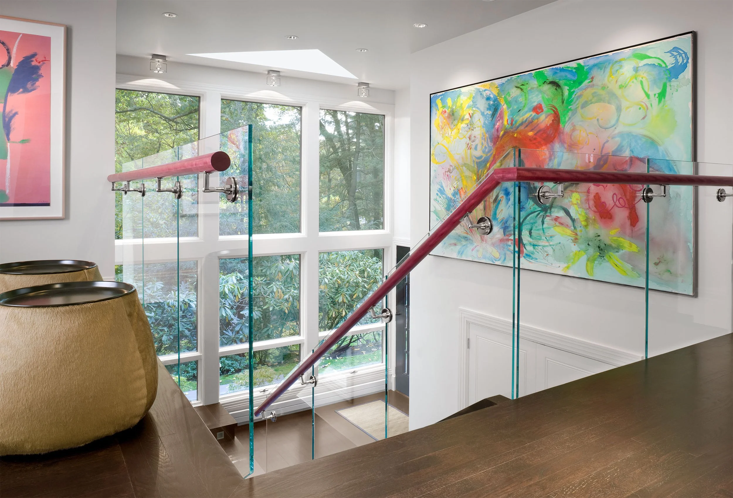 A modern entryway with a wall of windows looking out to a suburban yard
