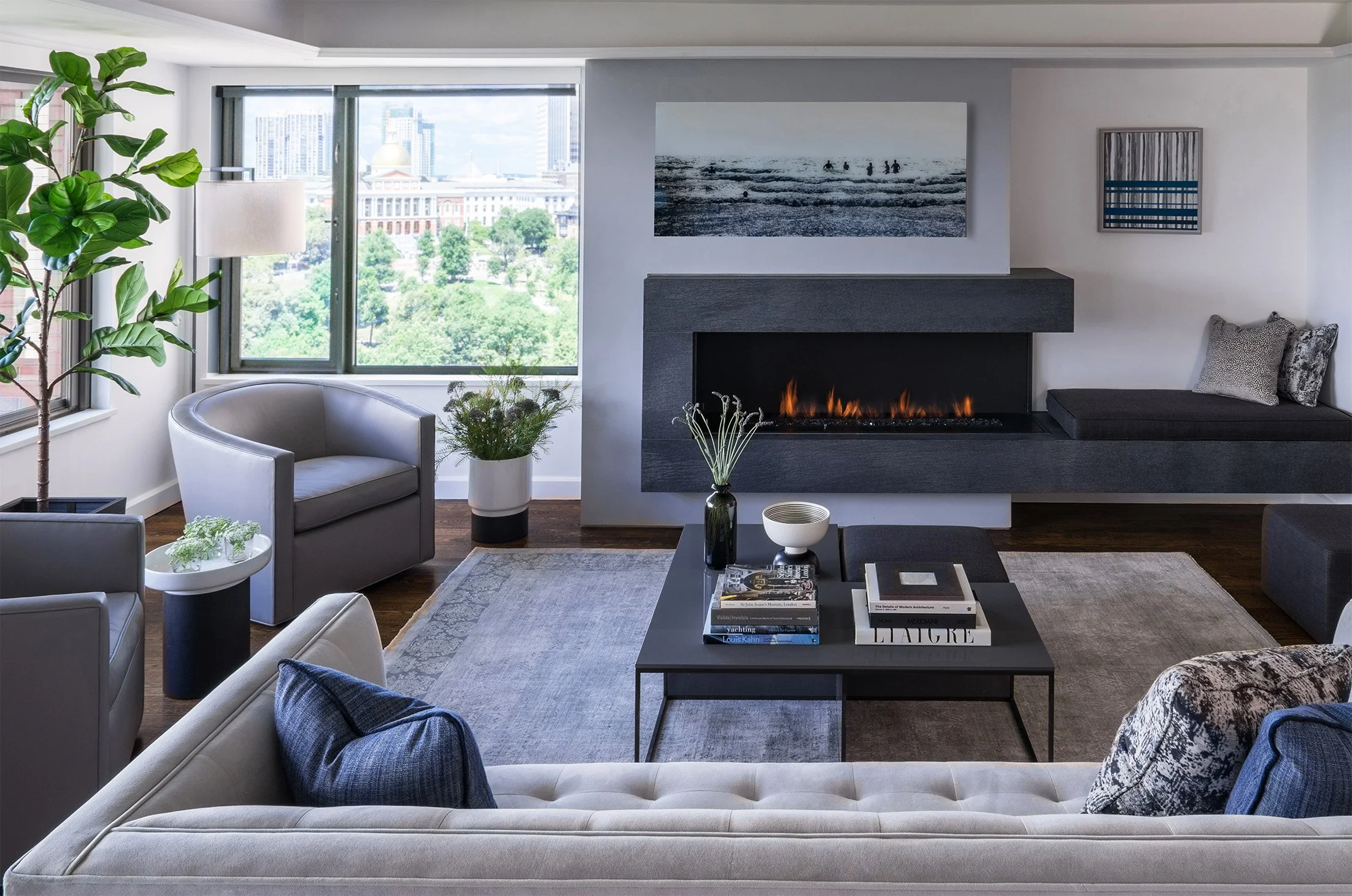A contemporary penthouse living room with a custom gas fireplace with integrated bench seat and modern furnishings