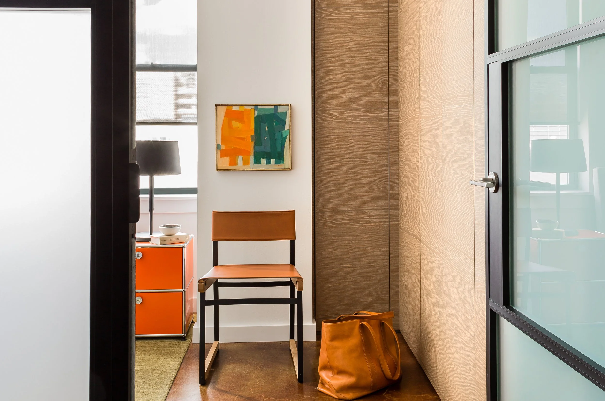 Modern bedroom with a steel and glass door in a SoWa loft