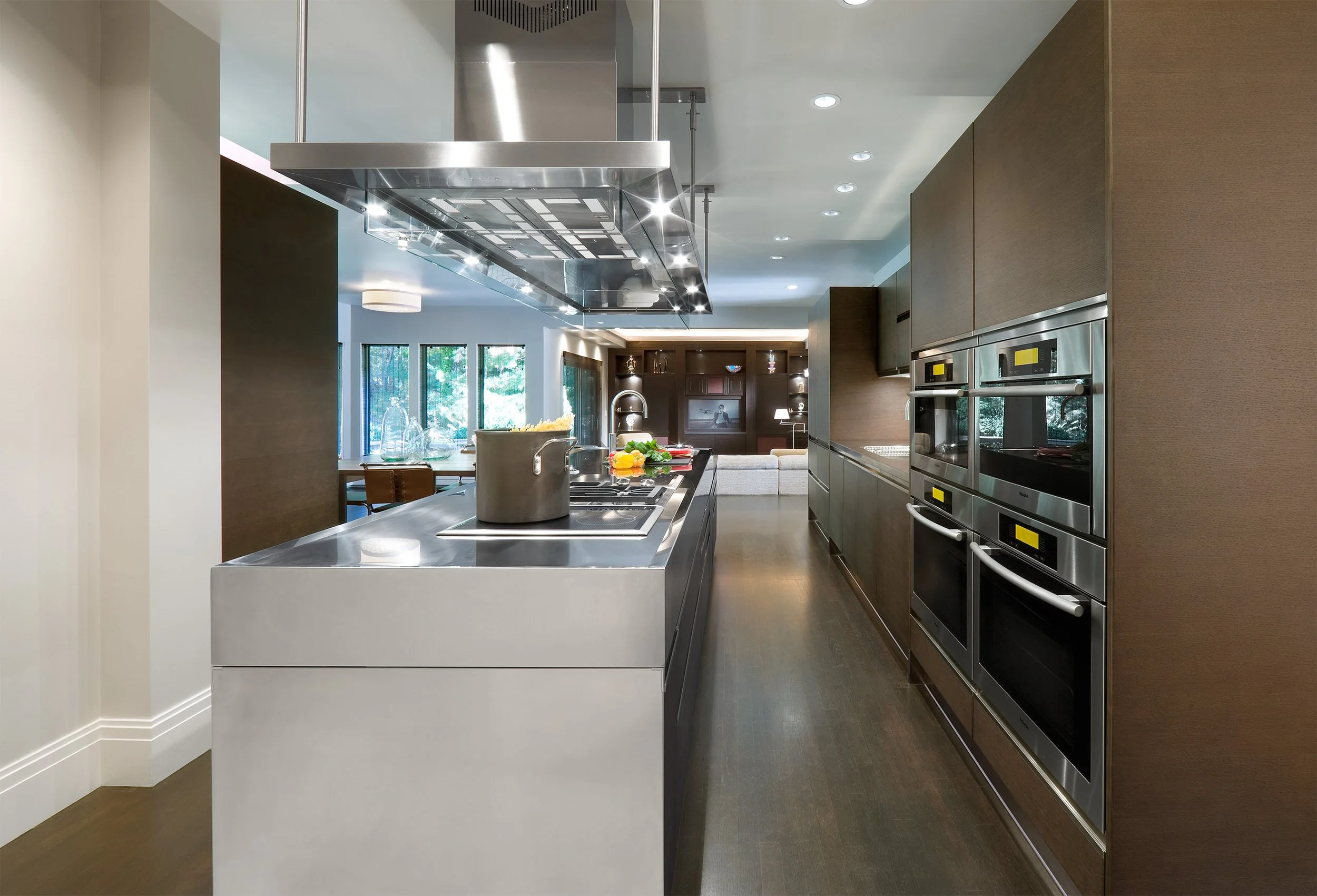 A stainless-steel island in a modern kitchen with dark wood cabinets