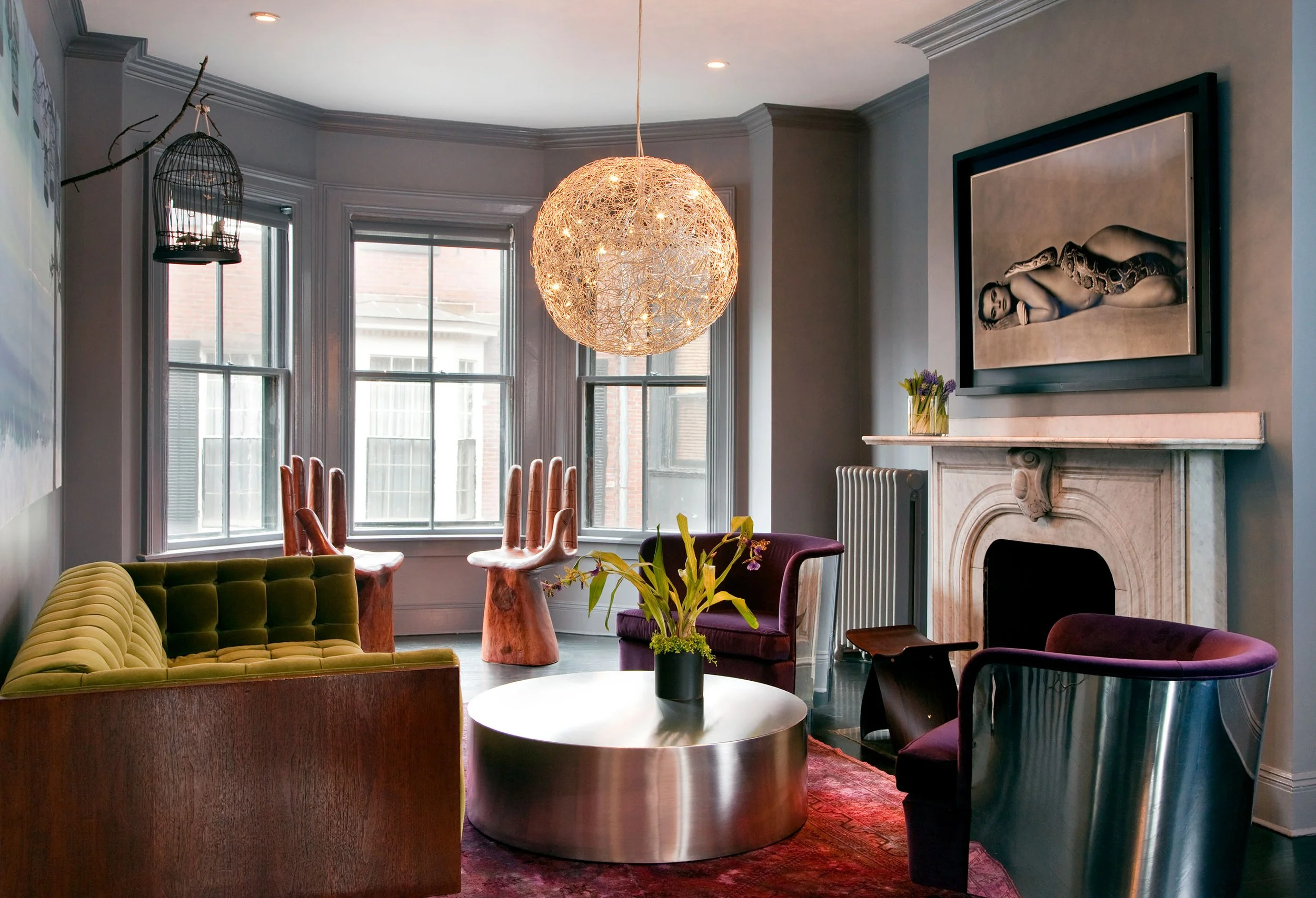 Moody gray living room in a renovated historic townhouse featuring modern furniture in jewel tones