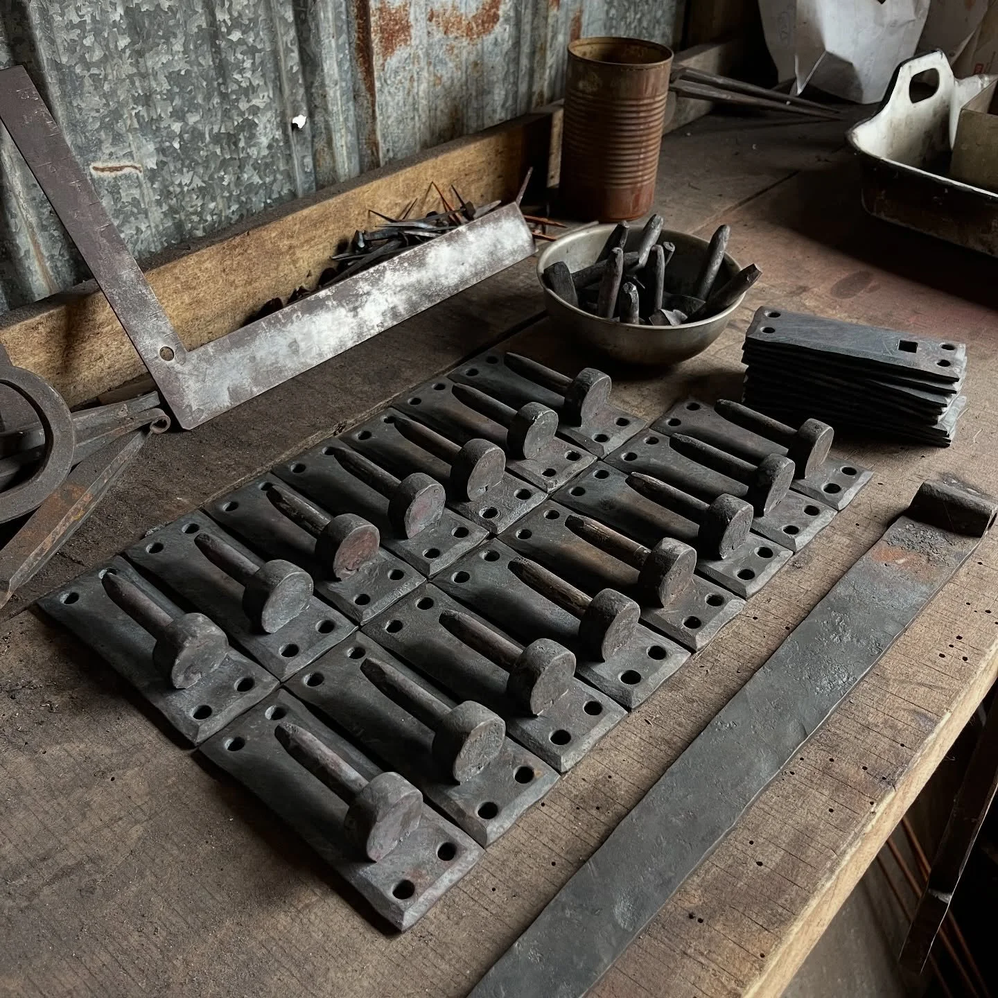 We&rsquo;ve been hard at work on a large batch of shutter hardware for @bureauinteriordesign. Part of the batch consists of two dozen strap hinges. Here the pintles are piling up on @e.sammons_and_co&rsquo;s bench while I&rsquo;ve been working on the
