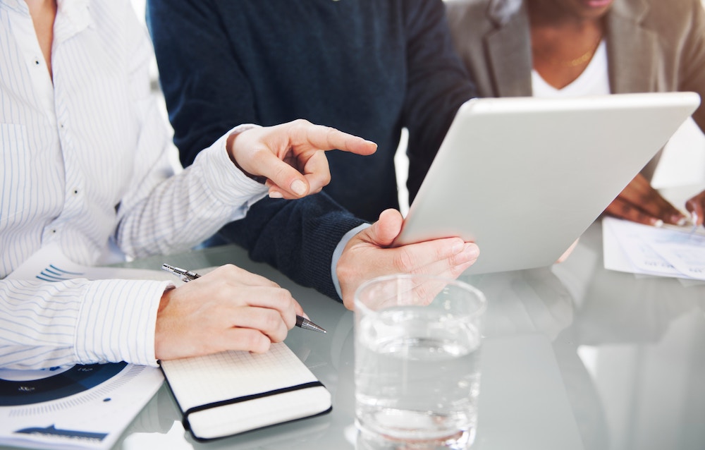 Business people reviewing a report on a tablet.
