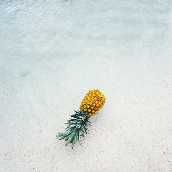 A pineapple on a beach.