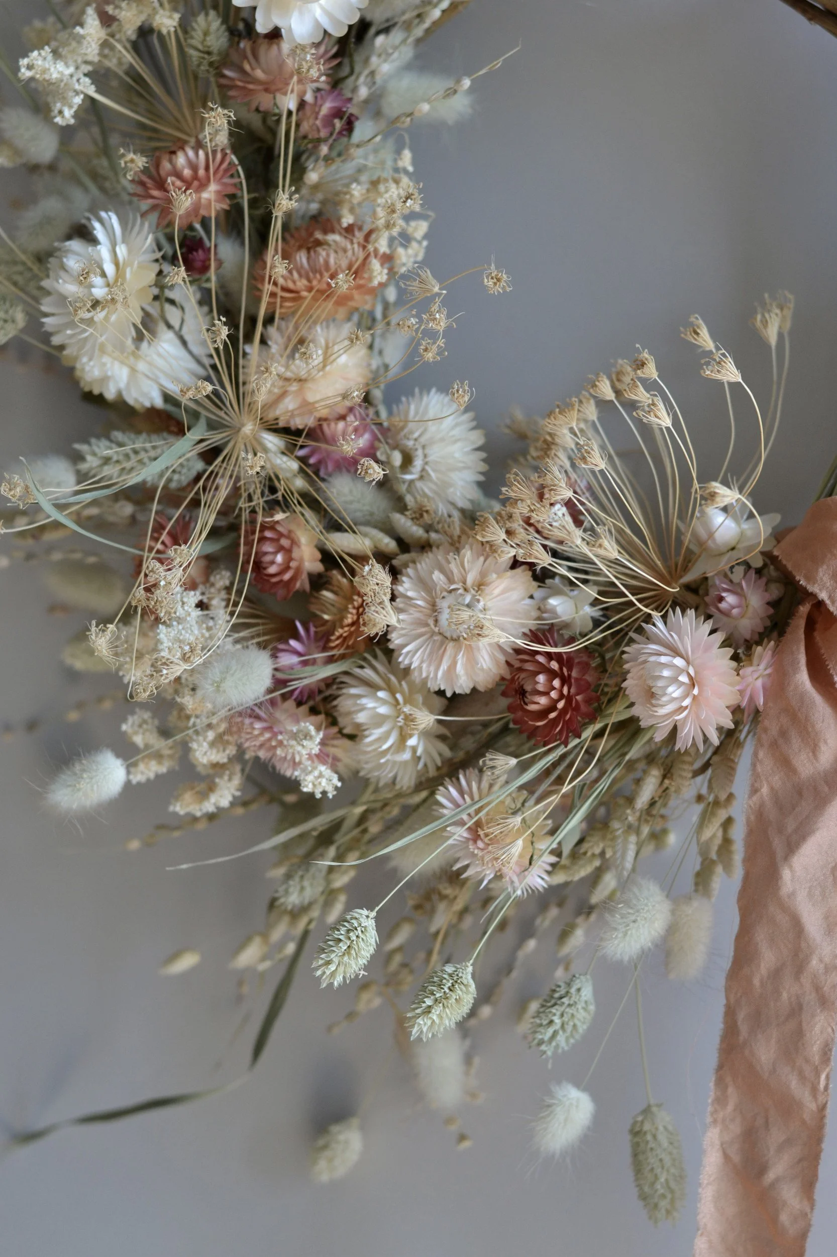 Close up of dried flowers in colours of pale pink, white and apricot-orange.
