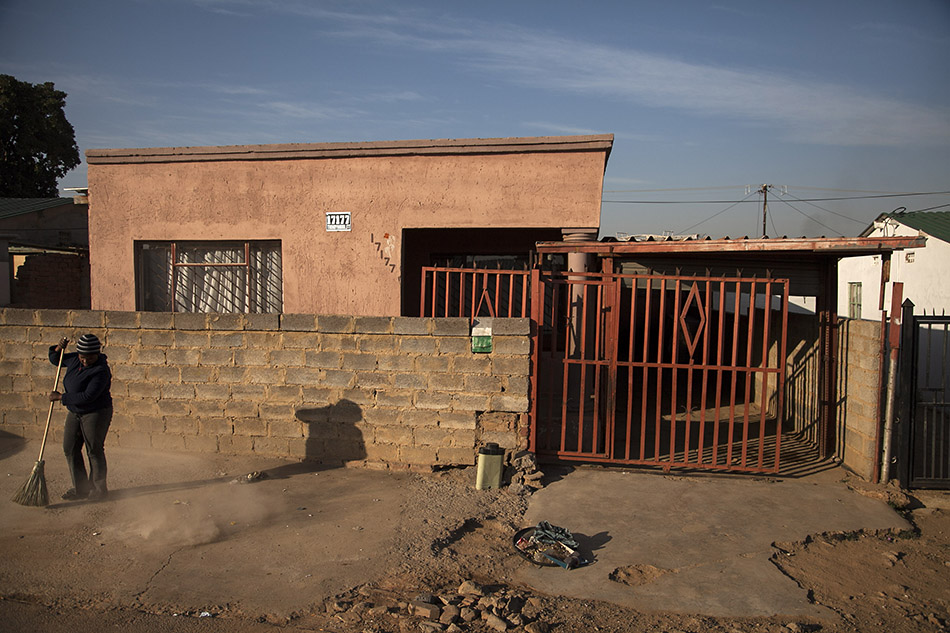  Ayanda Mathebula sweeps outside her family's home in Mamelodi, South Africa. She dreams of becoming a social worker but first she must pass her last two matric exams, which she failed before. She sometimes finds it hard to study because she must car