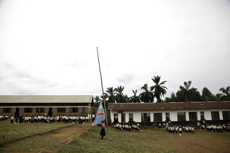 A schoolgirl pulls down the Democratic Republic of the Congo flag at a primary school on Idjwi Island. Idjwi, which is in the middle of Lake Kivu between Rwanda and the mainland DRC, has been a safe haven for the past 30 years for people fleeing vio
