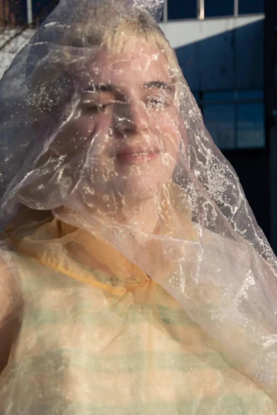 A dancer's face covered by transparent fabric.