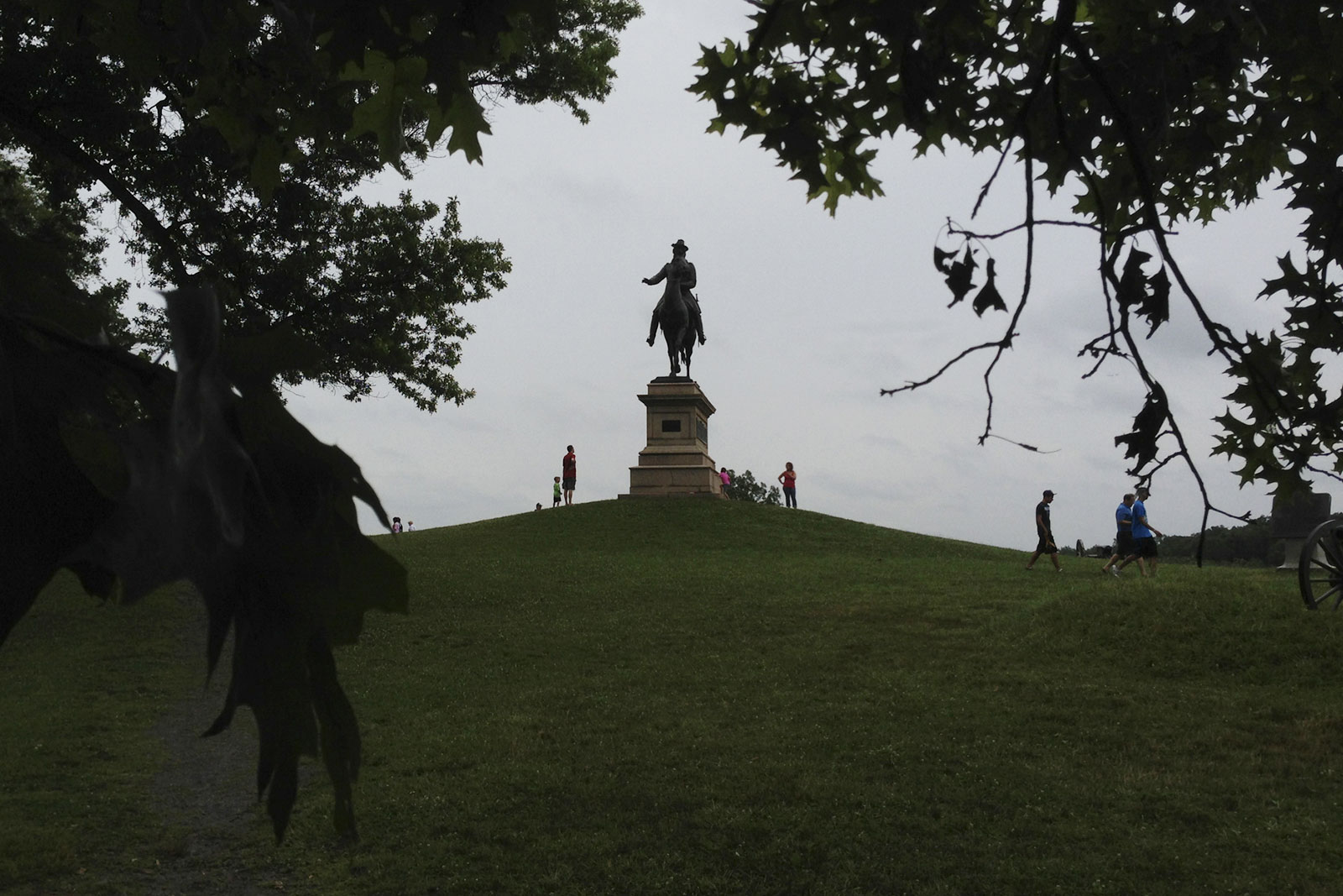 Visitors to Gettysburg National Battlefield Park are dwarfed by a statue near the Soldier’s National Cemetery.