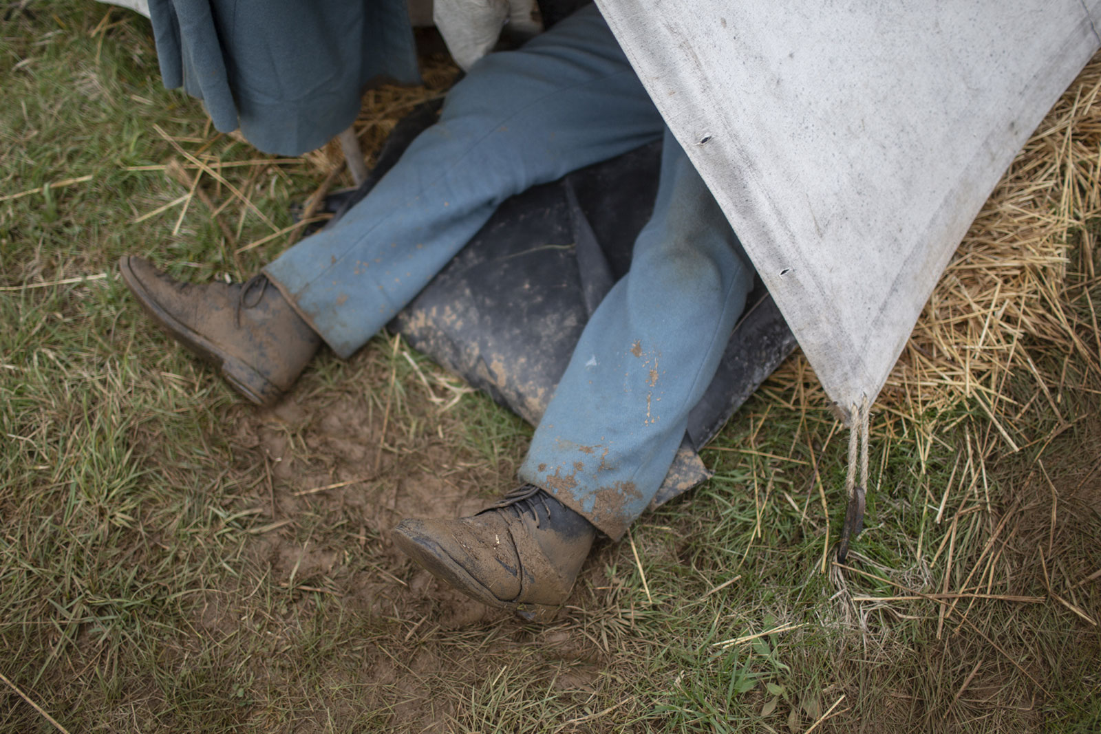 The muddy brogans of a Union reenactor stick out from under his small canvas tent.