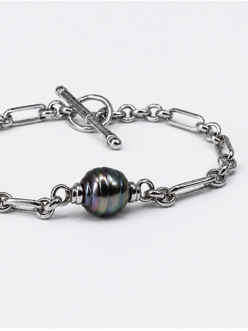 Eddy sterling silver figaro chain bracelet featuring a spinning dark Tahitian pearl, by Charlotte Garnett
