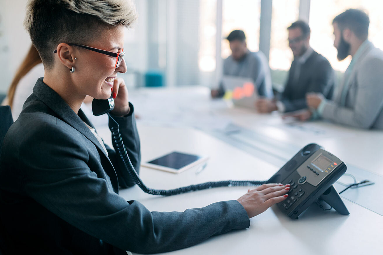 woman-on-phone-in-busy-modern-office-8DRLG6H.jpg