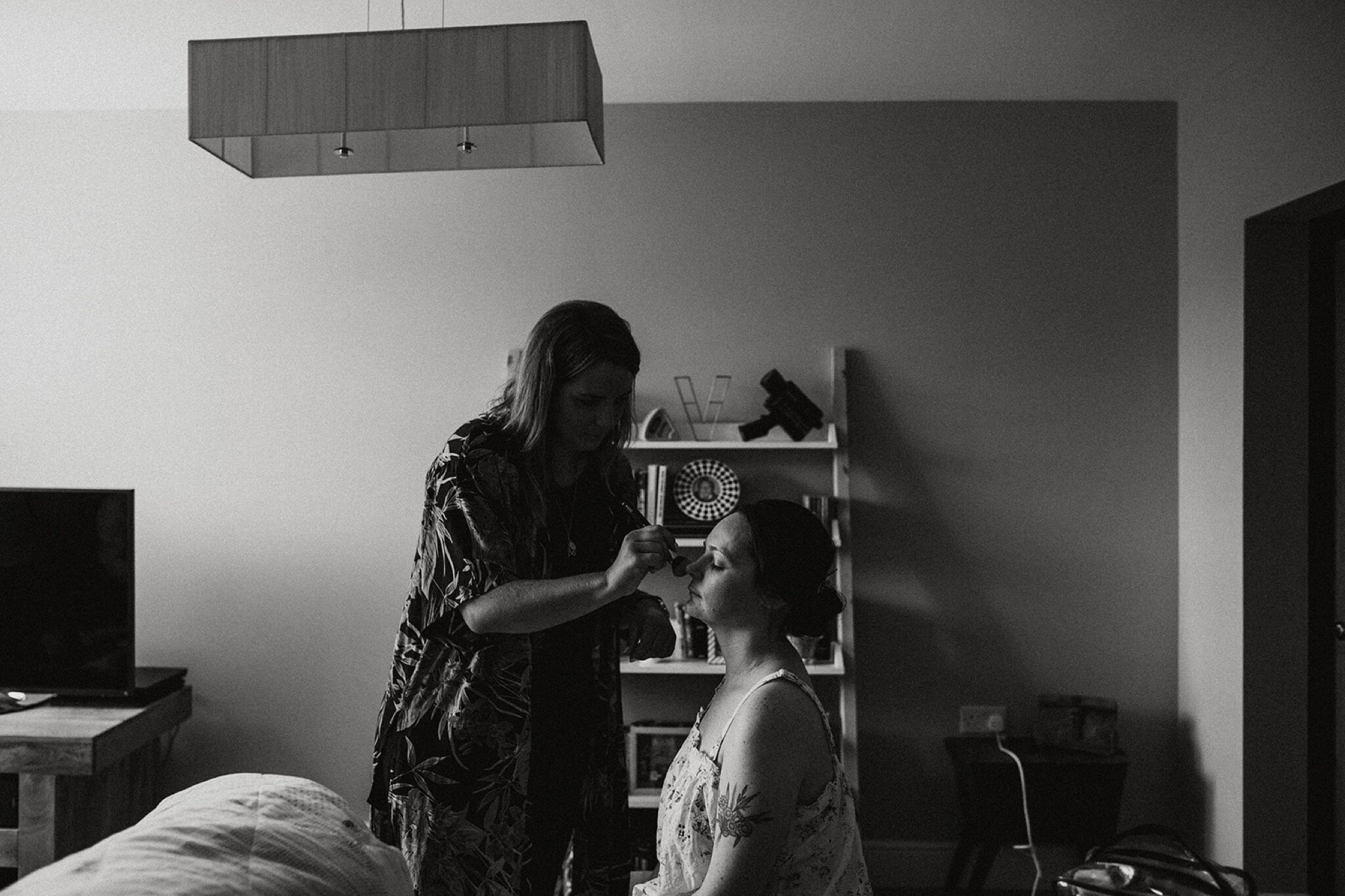 02_V+D Wedding-14_Black and white photo of a bride having her make-up done in her living room%0A.jpg