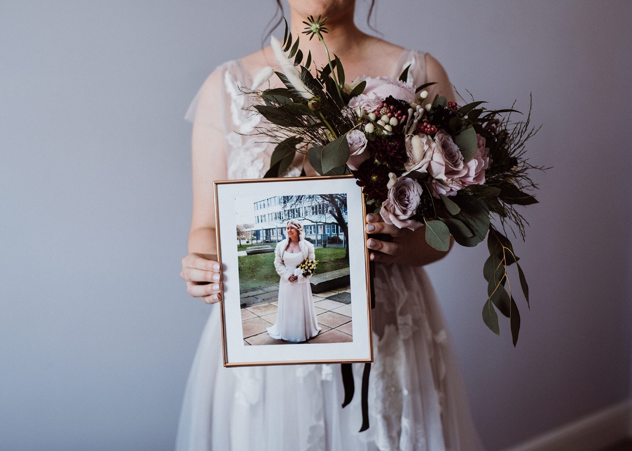 09_V+D Wedding-115_close up of bride holding her wedding bouquet and  a photo of her own mother in her wedding dress..jpg