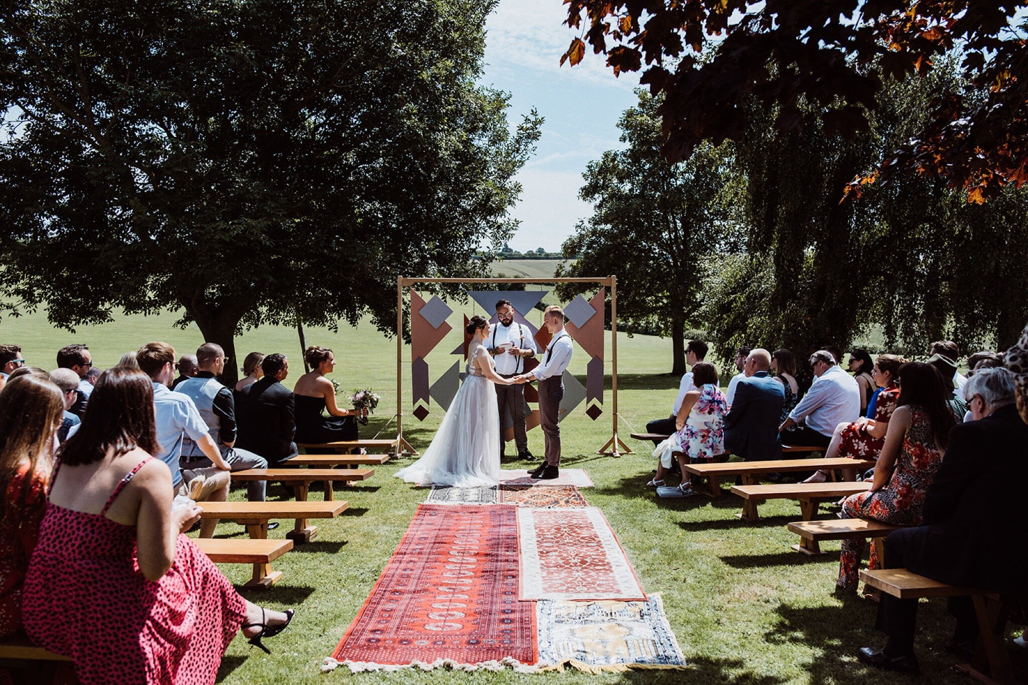 17_V+D Wedding-206_Wide photo of groom, bride, celebrant and wedding guests during a Summer outdoor humanist wedding ceremony..jpg