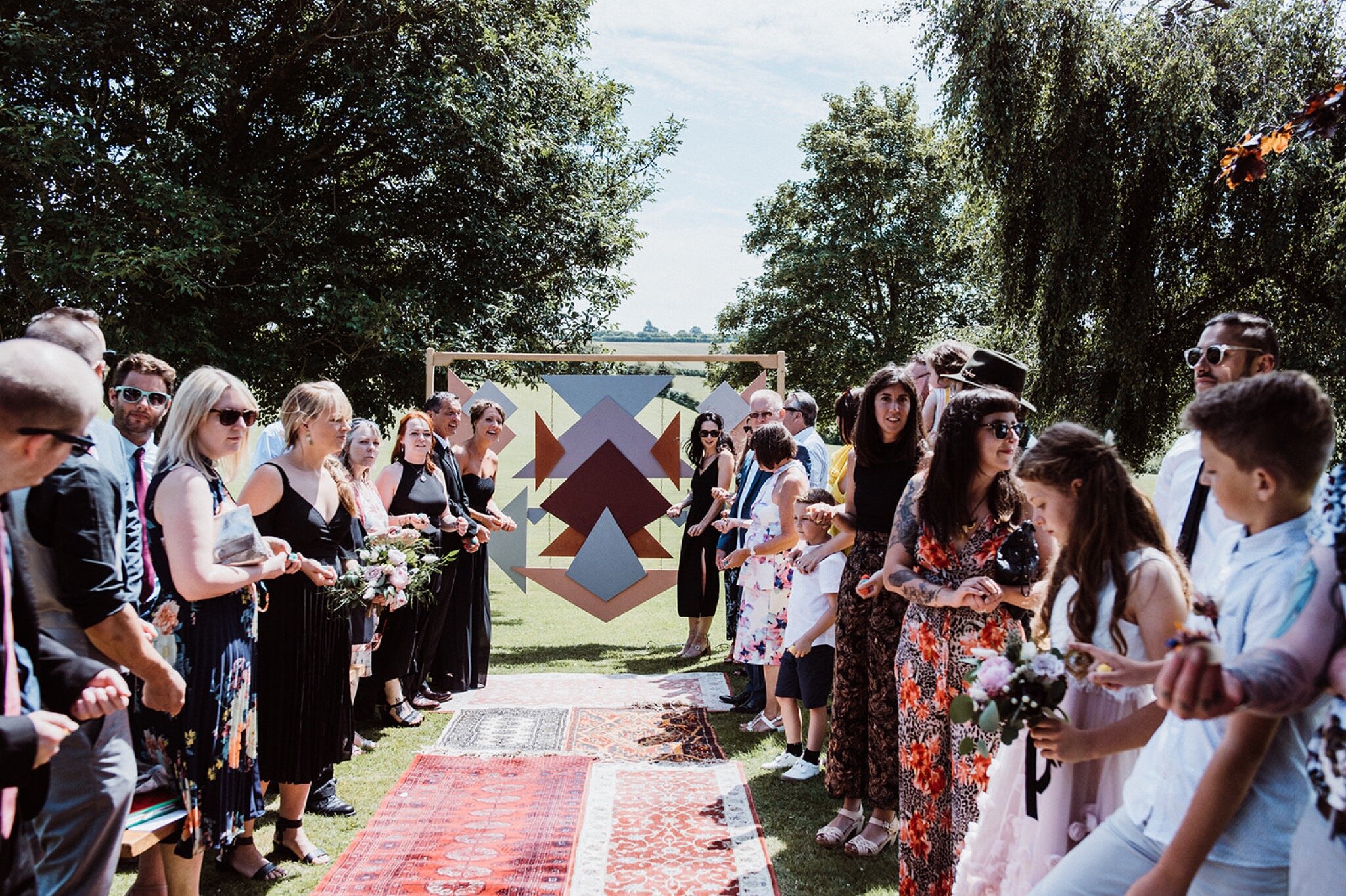 21_V+D Wedding-234_guests lining up to throw confetti after Summer outdoor humanist wedding ceremony..jpg