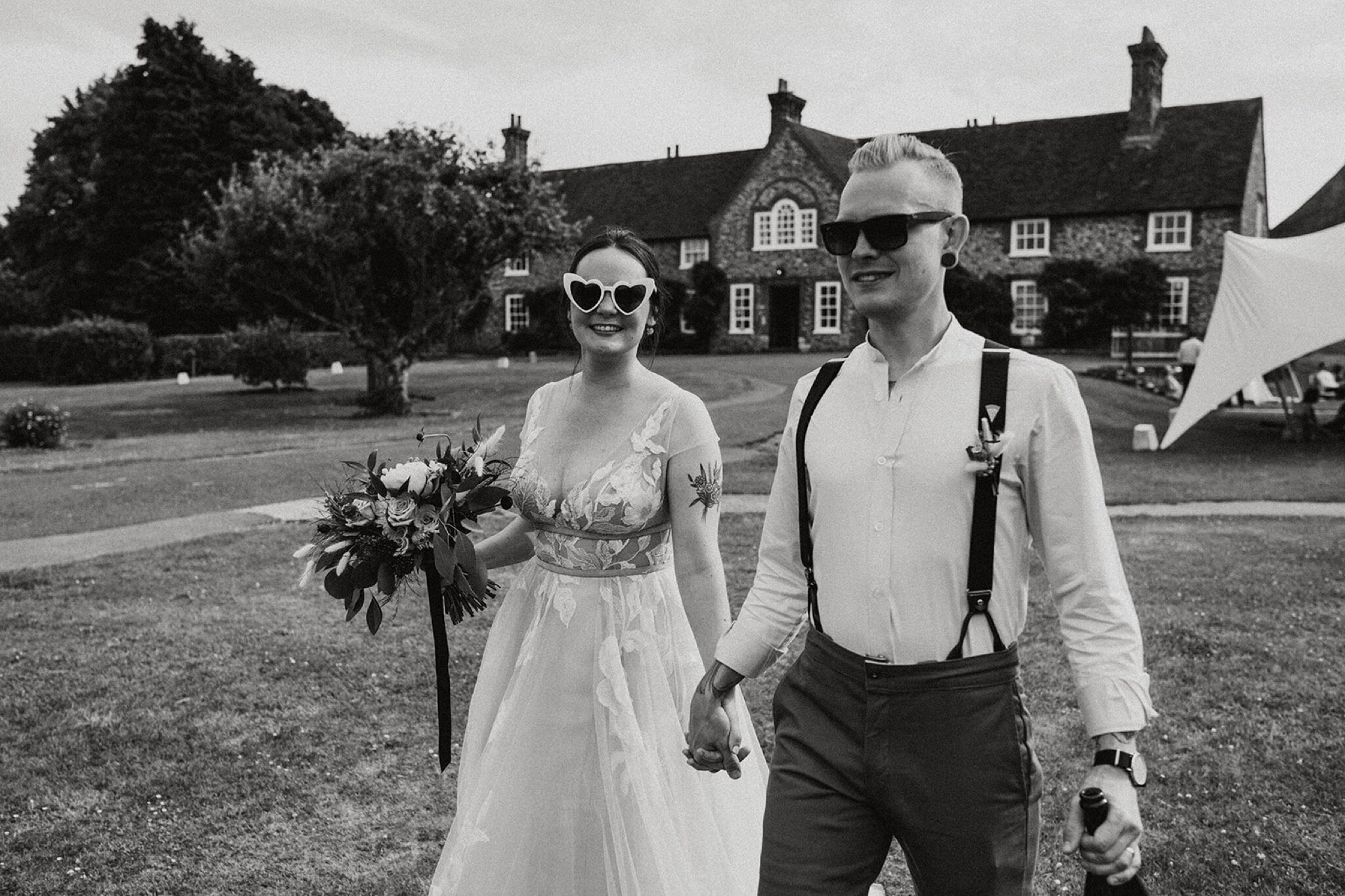 41_V+D Wedding-678_websize_black and white photo of bride and groom holding hands wearing sunglasses.jpg