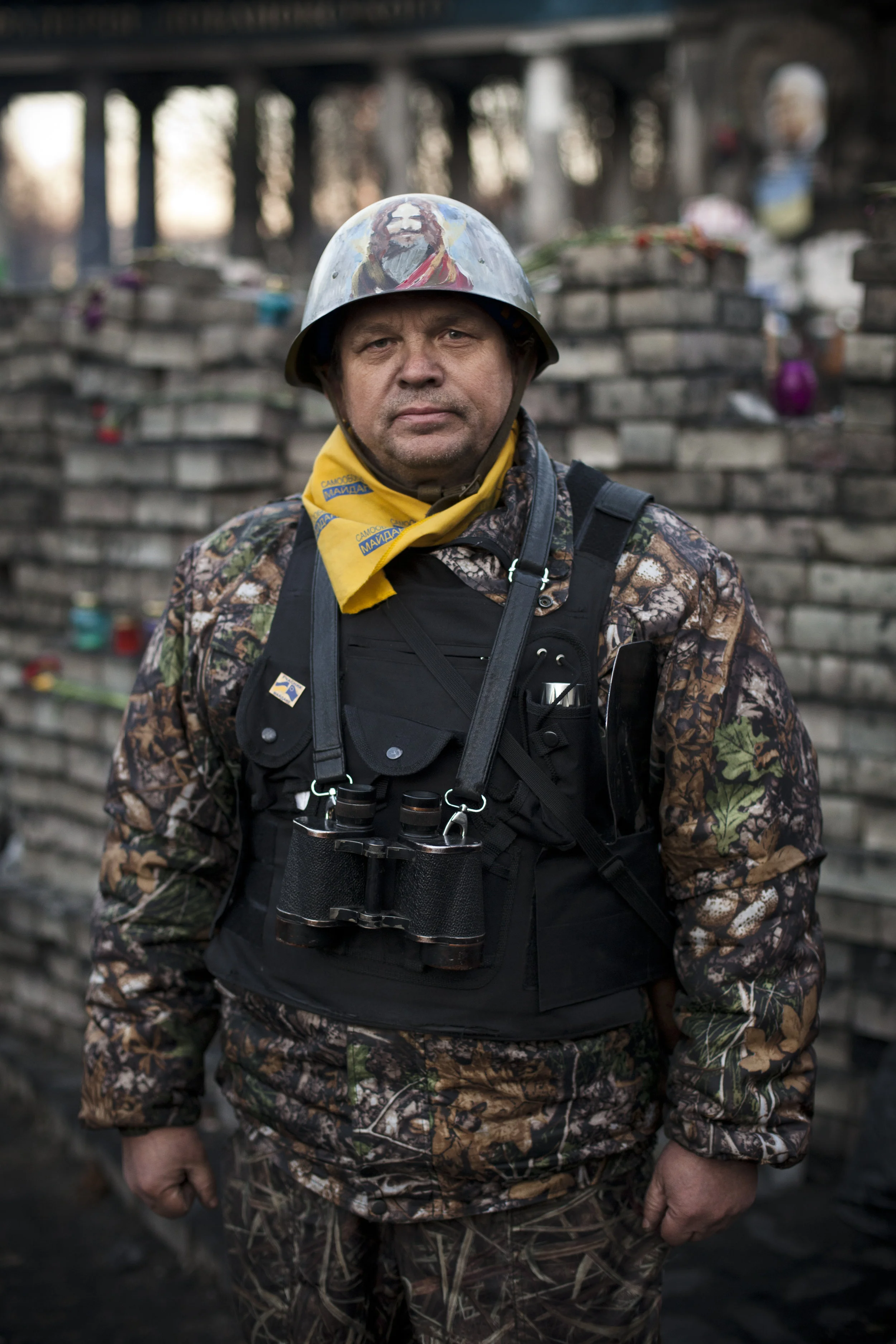 A member of a self defense volunteer group poses for a photograph next to a barricade located near the entrance to the Dynamo Kyiv soccer club stadium in Kiev's Independence Square, Ukraine, Wednesday, March 12, 2014. (AP Photo/David Azia)