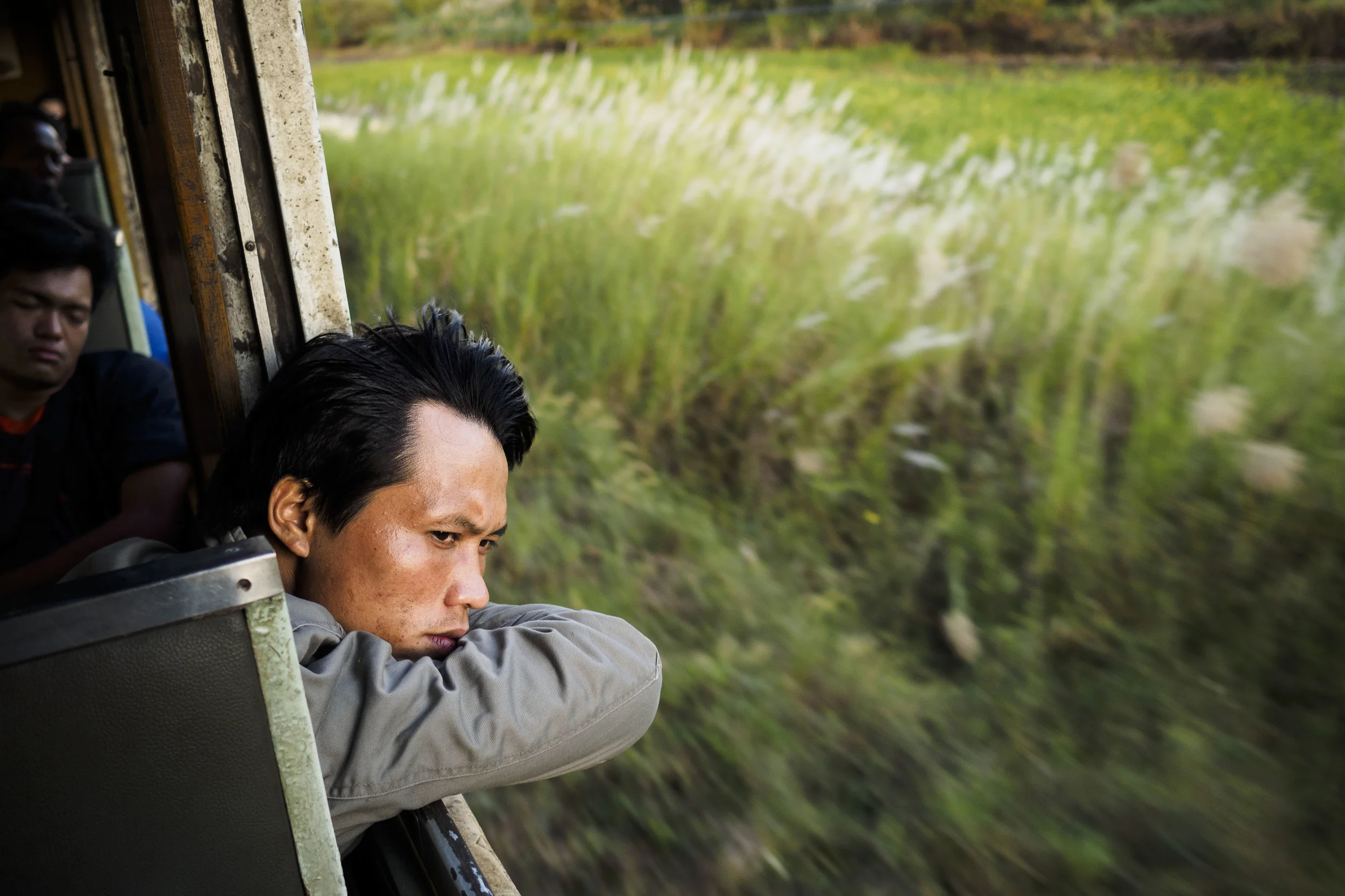A man looks out of the window of a train running between Aranyaprathet and Bangkok, Thailand, Monday, Nov. 25, 2013.