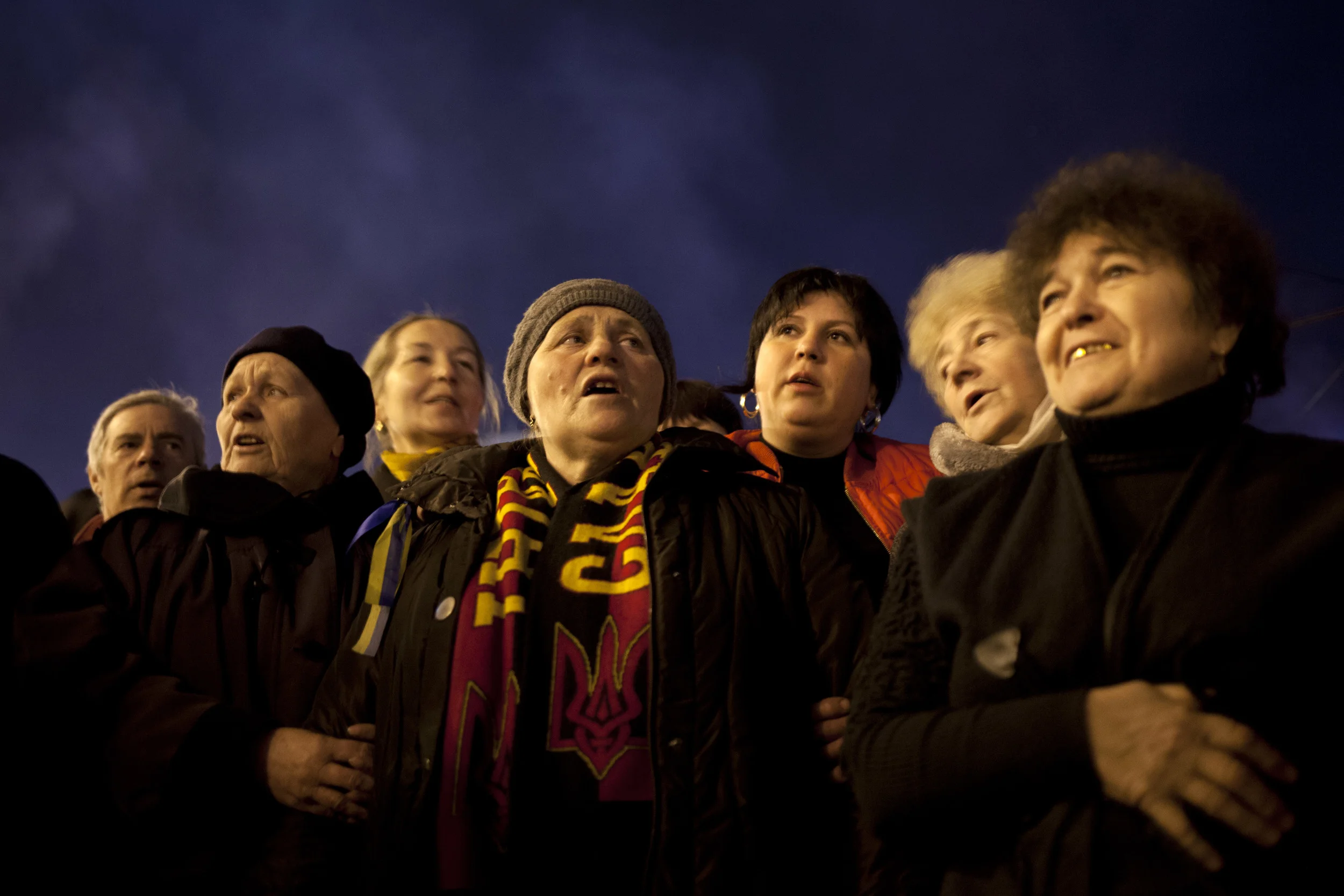Ukrainian men and women sing the national anthem in Kiev's Independence Square, Ukraine, Saturday, March 8, 2014. (AP Photo/David Azia)