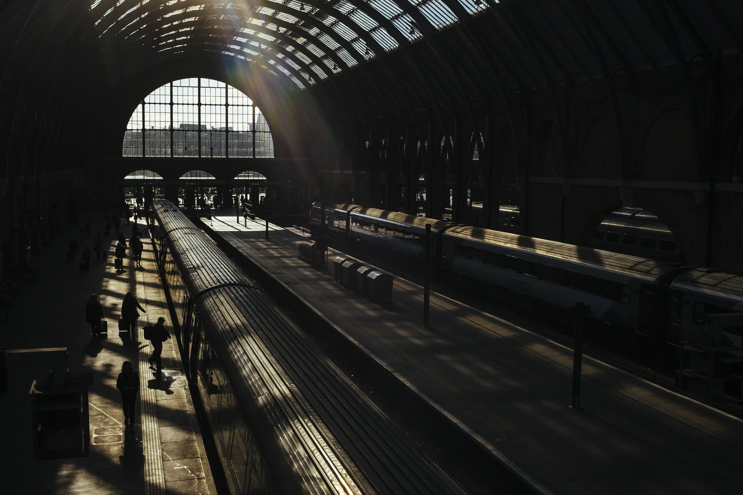 Passengers walk alongside a waiting train at a platform at King's Cross railway station, London, Wednesday, Feb. 18, 2015.